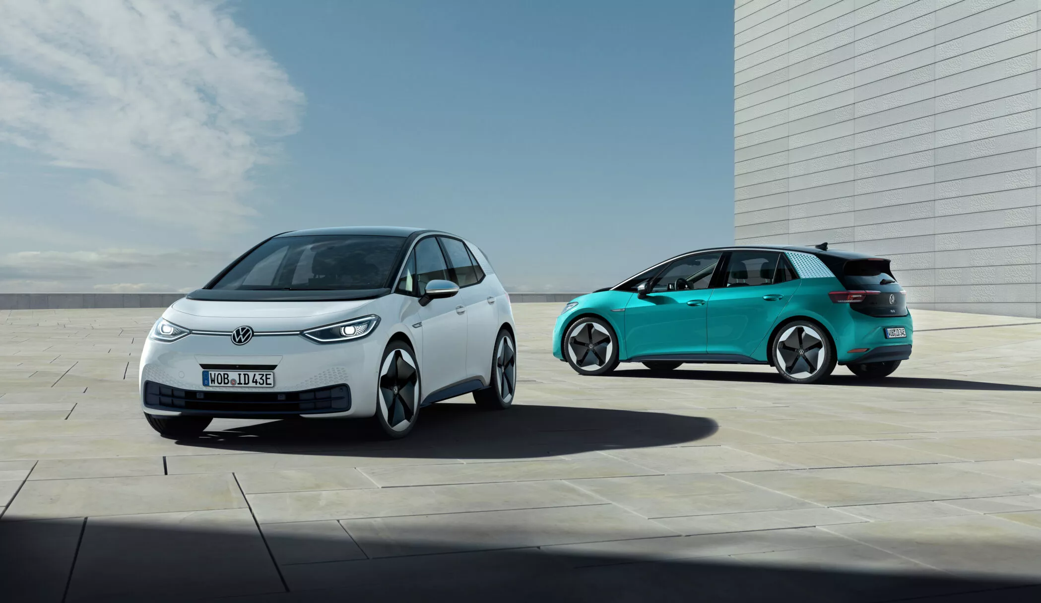 Volkswagen ID.3 en blanc et turquoise, vue de deux versions de la compacte électrique dans un décor moderne