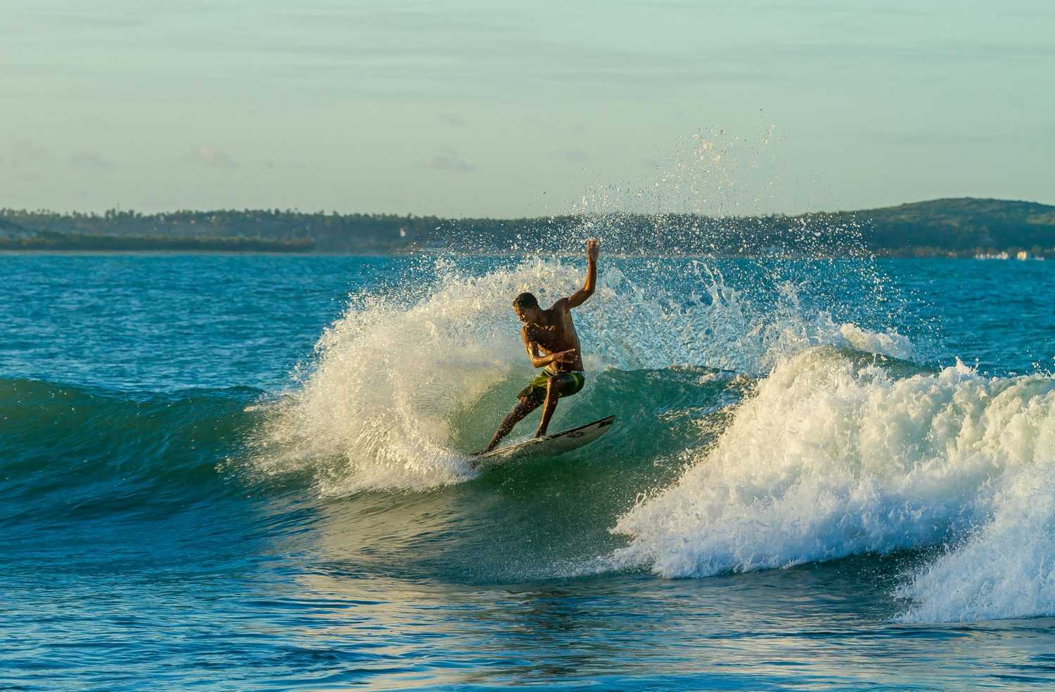Man surfing on a wave – best-time-to-surf-understanding-tides-swell-and-wind.
