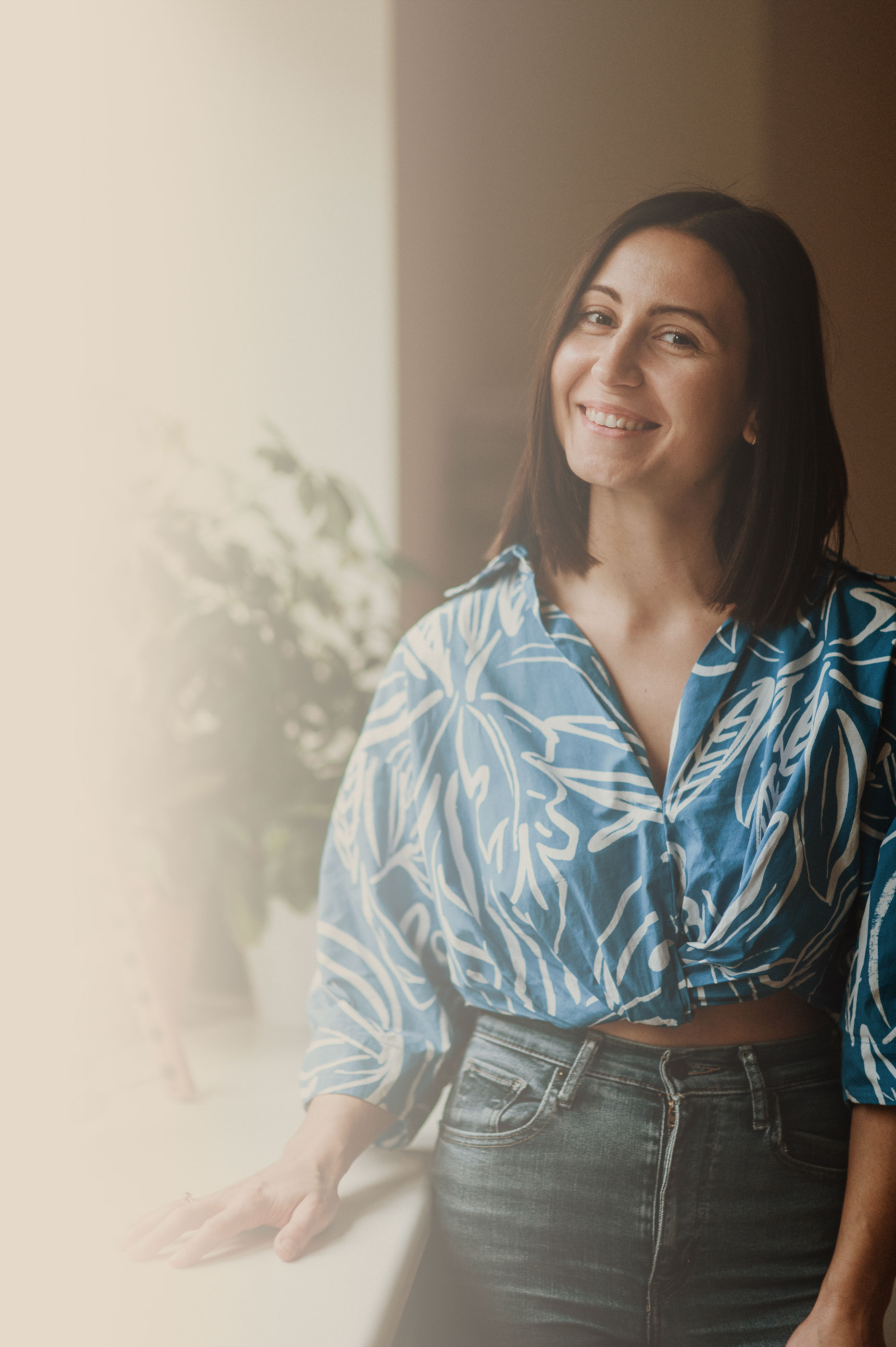 Uśmiechnięta, młoda kobieta w casual'owej koszuli.