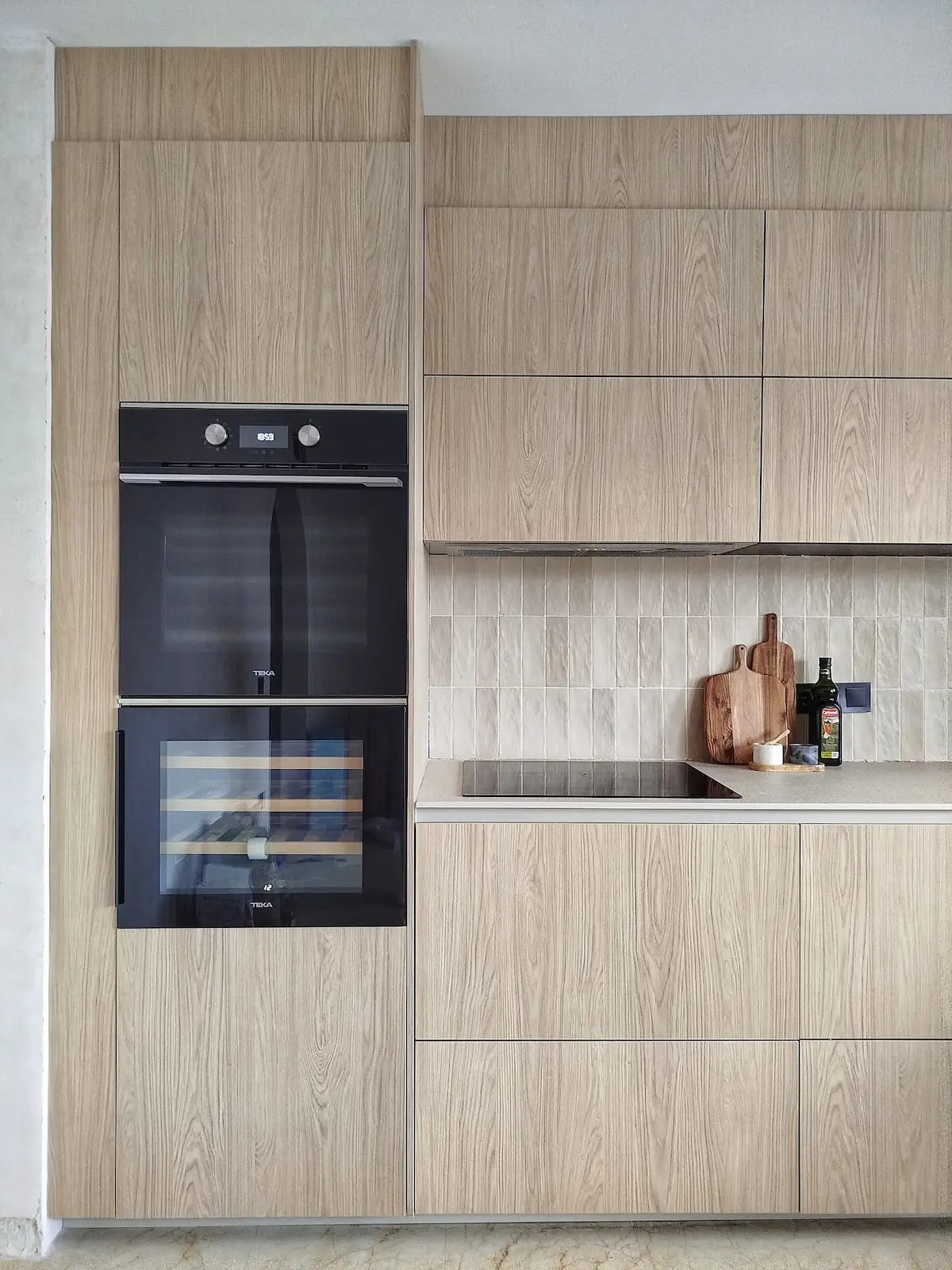 Hochwertiges Interior-Design-Konzept mit moderner Küche, Backofen und integriertem Weinkühlschrank.