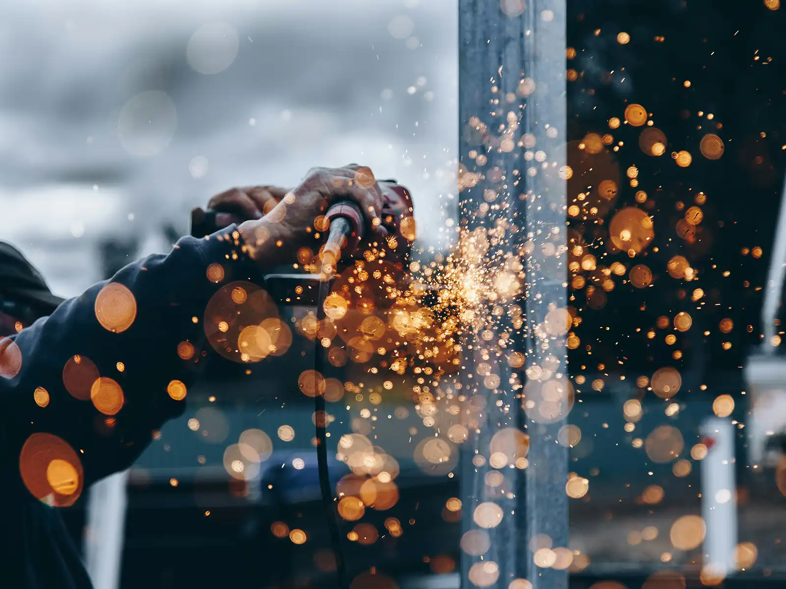 Photo of man welding metal as sparks fly