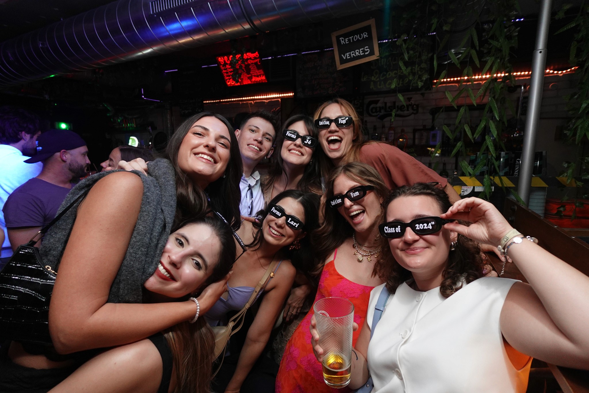 Group of friends wearing themed party glasses and smiling together during a birthday pub crawl in Nice capturing a fun group celebration and social nightlife experience in the French Riviera
