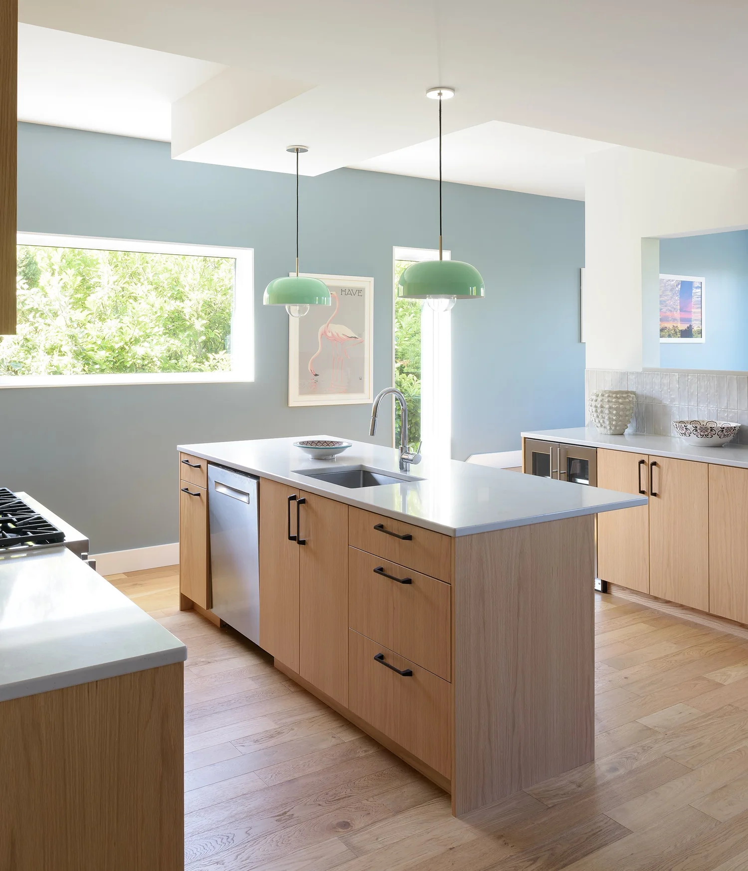 Modern two-story home with large glass windows, warmly lit interiors, and a balcony. Surrounded by trees and a manicured lawn at dusk. Cozy ambiance.