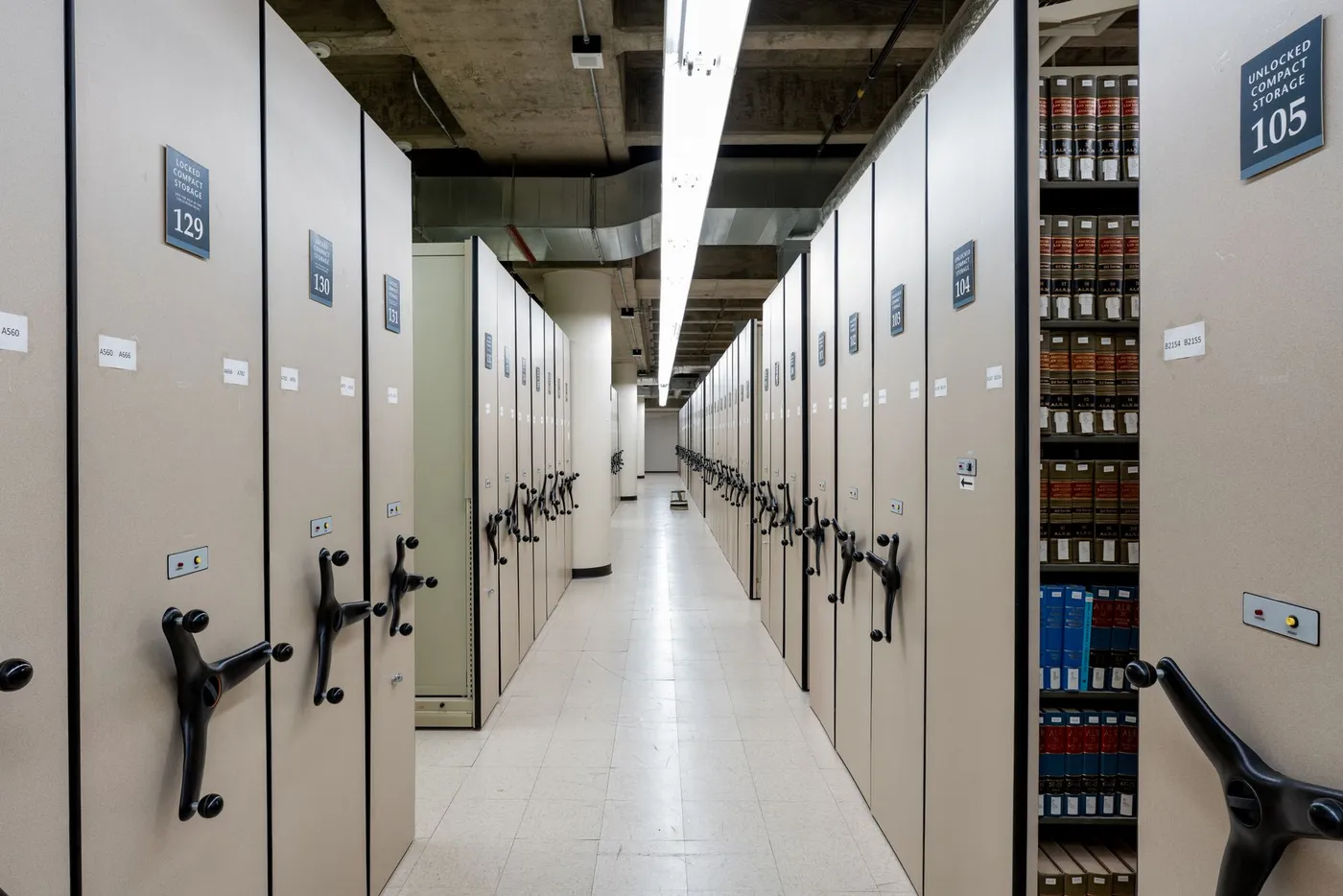 Rows of compact archive shelving holding boxed files and records