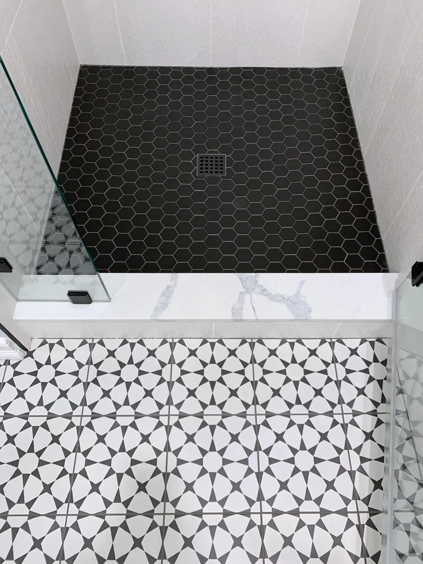 Overhead view of the guest bath shower pan, featuring hex tile design that adds a modern and unique touch to the bathroom. Photo by Todd Huge.