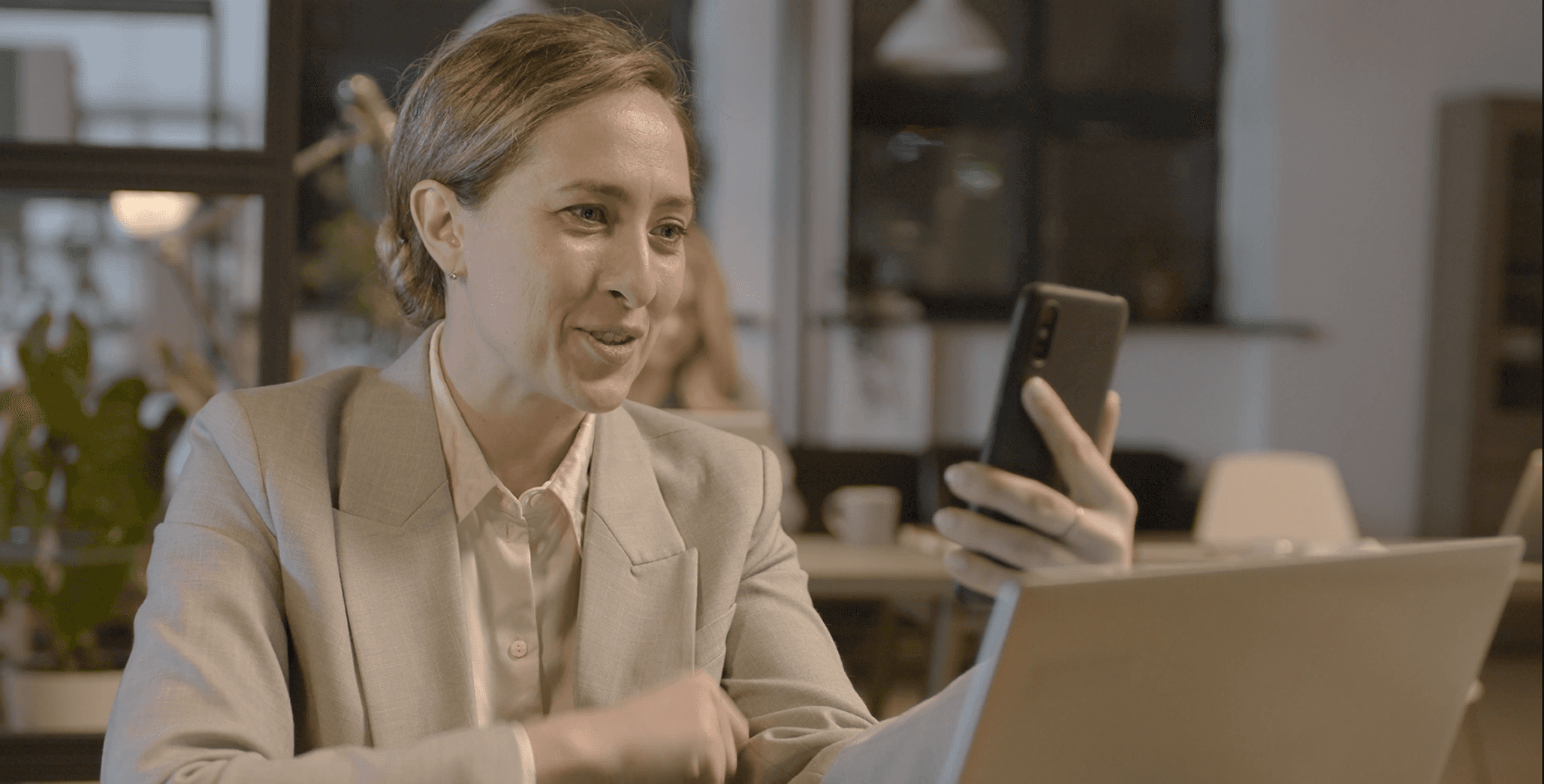 Female professional multitasking in an office setting, discussing data over the phone