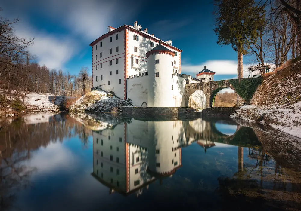 A perfect reflection of Snežnik castle in Slovenia on a sunny winter day.