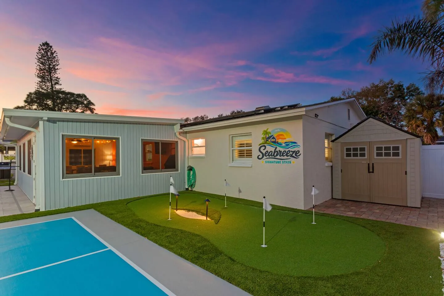 Putting green and court at sunset with Seabreeze logo on wall at Pickleball Resort, Bradenton, Florida