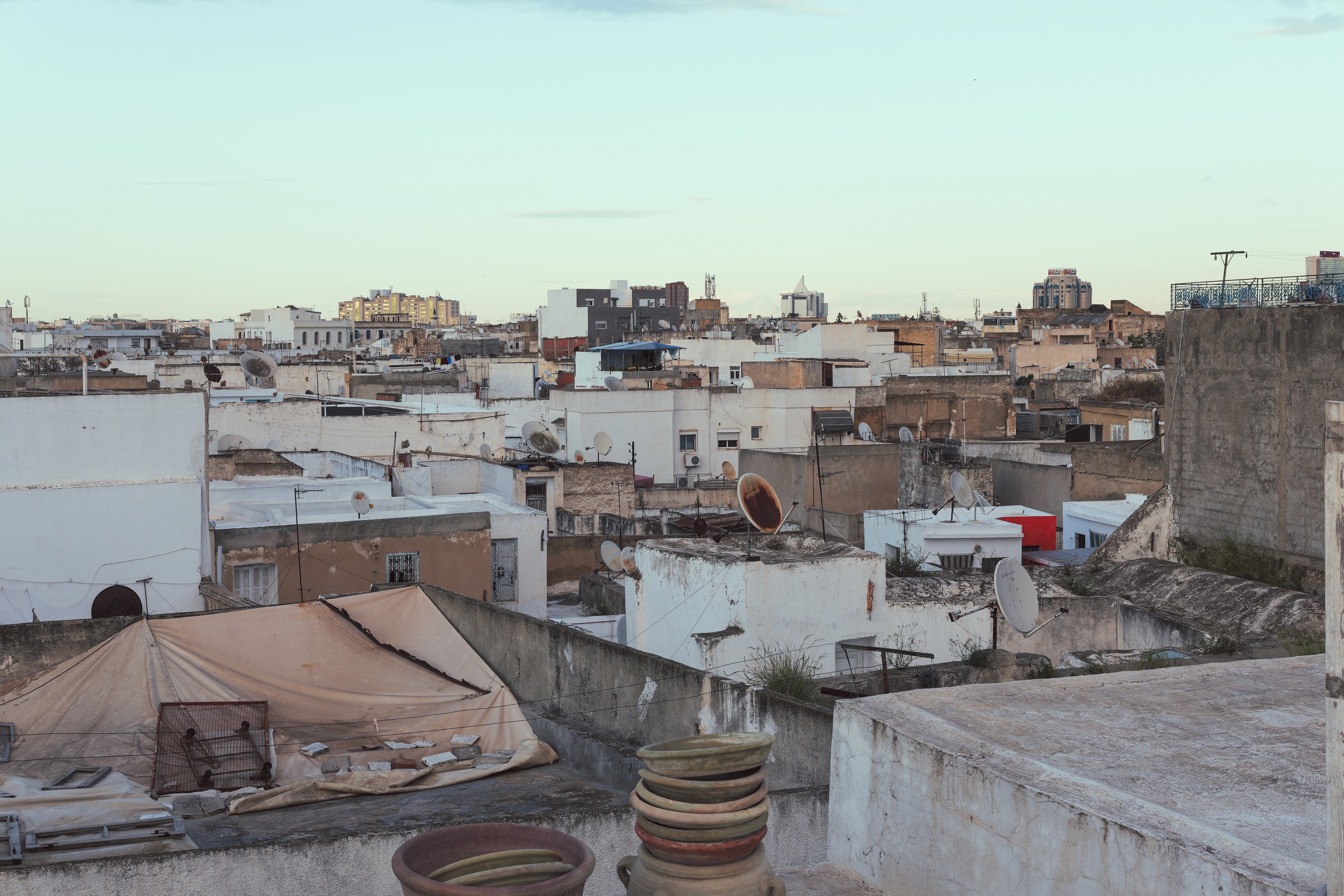 A young person wearing silver sports sunglasses lies on their stomach on a patterned rug, resting their chin on their hands while looking at an open magazine.