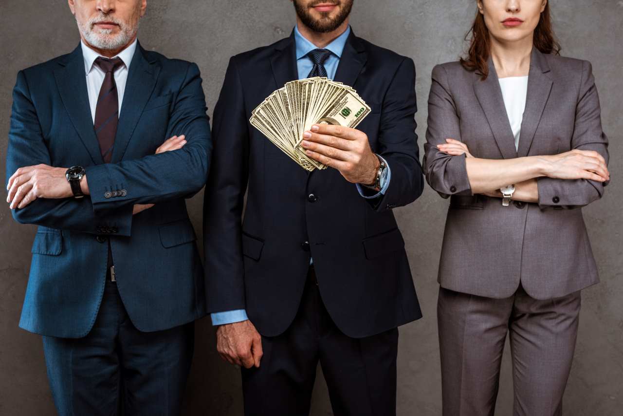 empresários segurando dinheiro nas mãos 