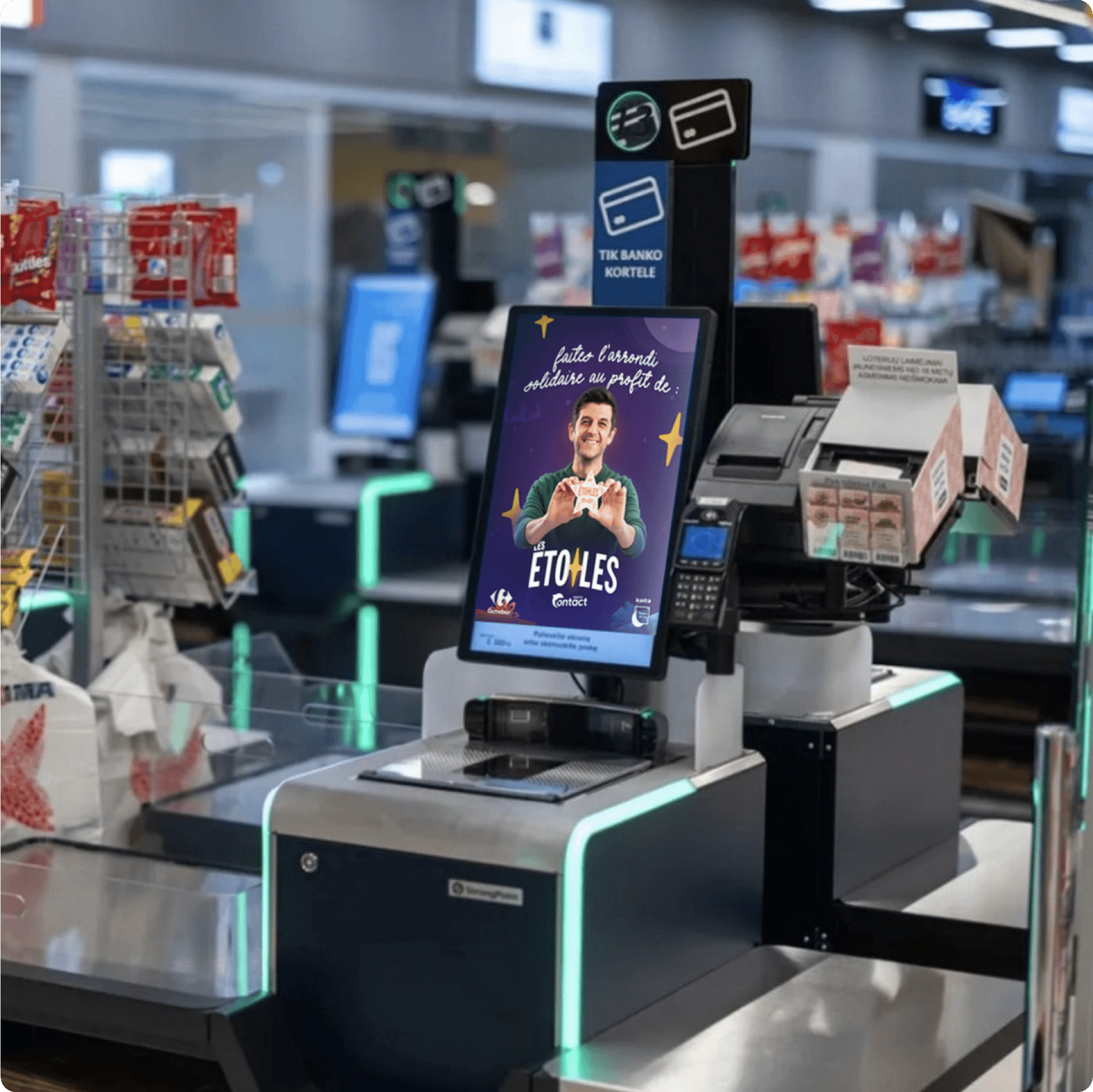Shiny metallic silver foil pouch lying flat, printed with a large black outline of a smiley face, all set against a bright orange backdrop.
