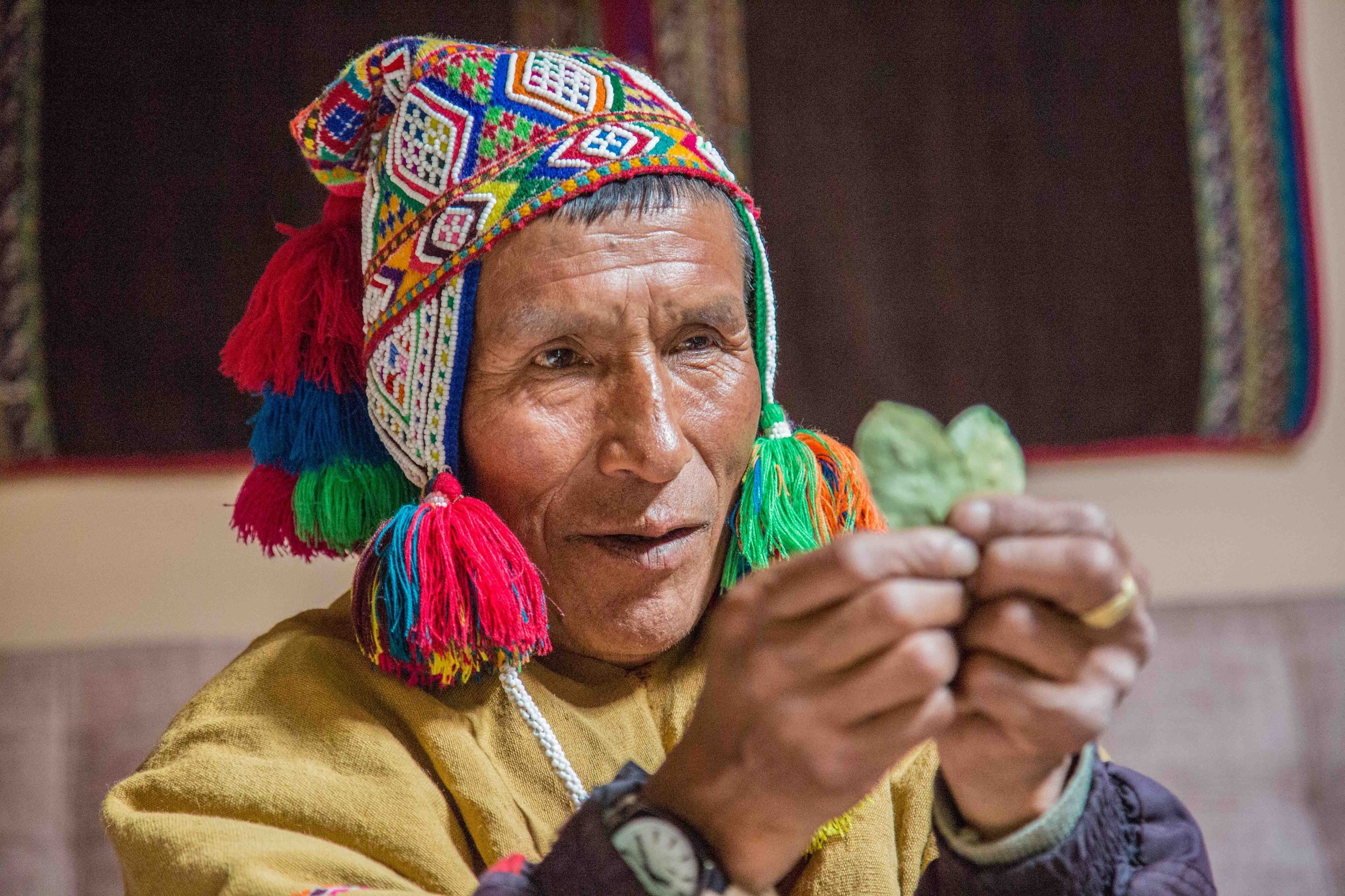 Captivating image of a traditional shaman skillfully using sacred coca leaves, showcasing the rich spiritual heritage and ancient practices of the Andes. Dive into the mysticism of Peru through this powerful visual.