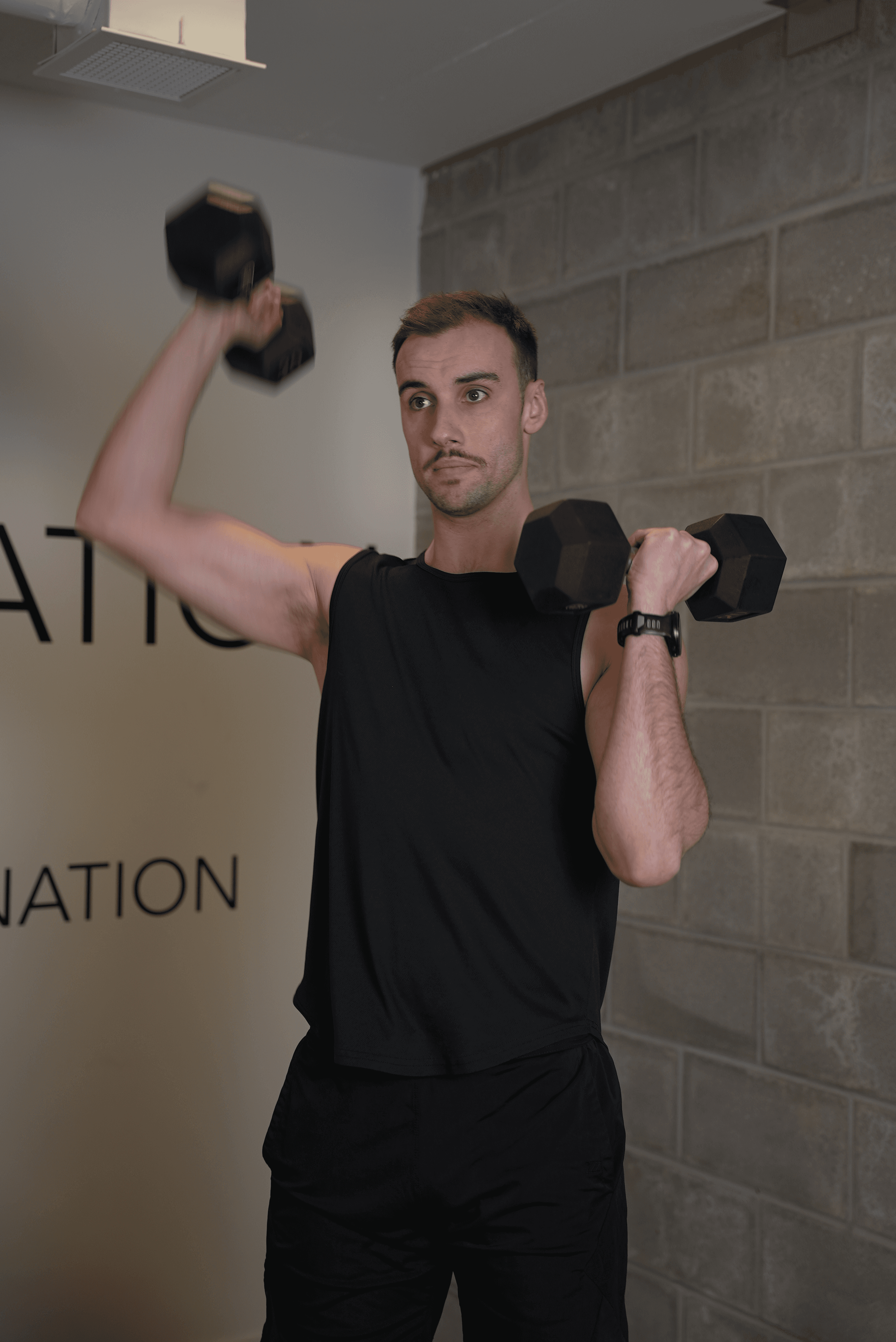 Étienne Gillard kinésiologue Progrès-Fit faisant un exercice avec haltères, démontrant un entraînement de 20 à 40 minutes à la maison ou au gym