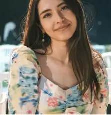 a woman sitting on a white chair next to a table