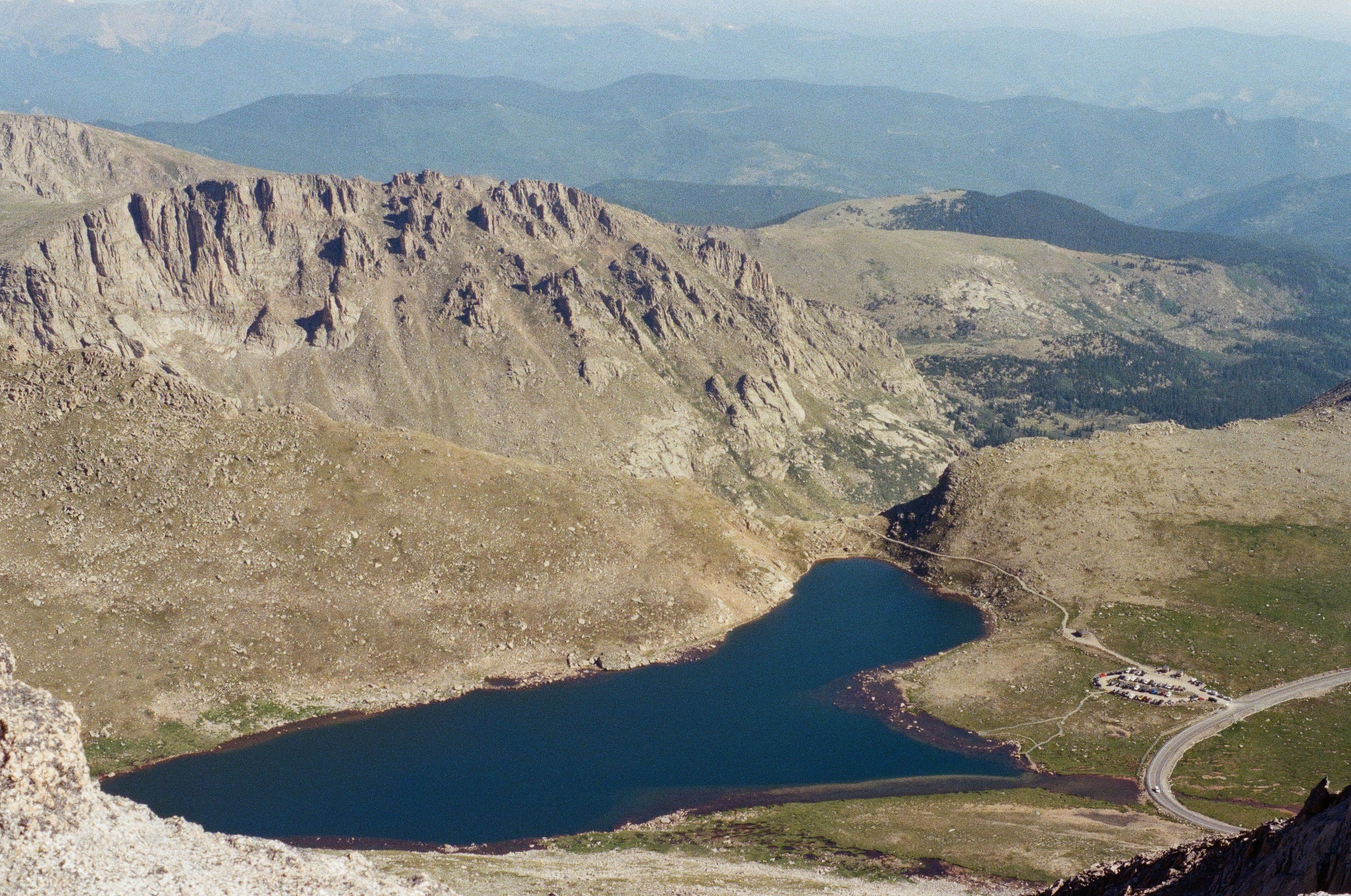 Picture of mountains sparsely covered in snow with a relatively clear blue sky behind them; mountain range in Colorado