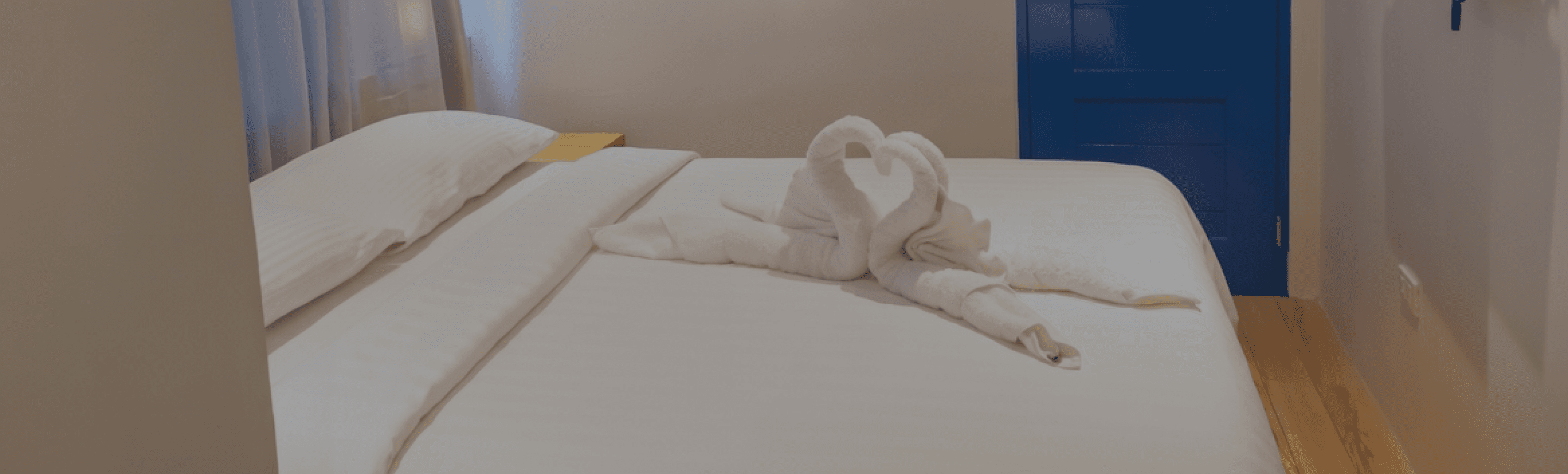 Double Room interior with signature glowing blue arched window, wooden bed and modern furnishings at Oktowaves Hotel Nasugbu