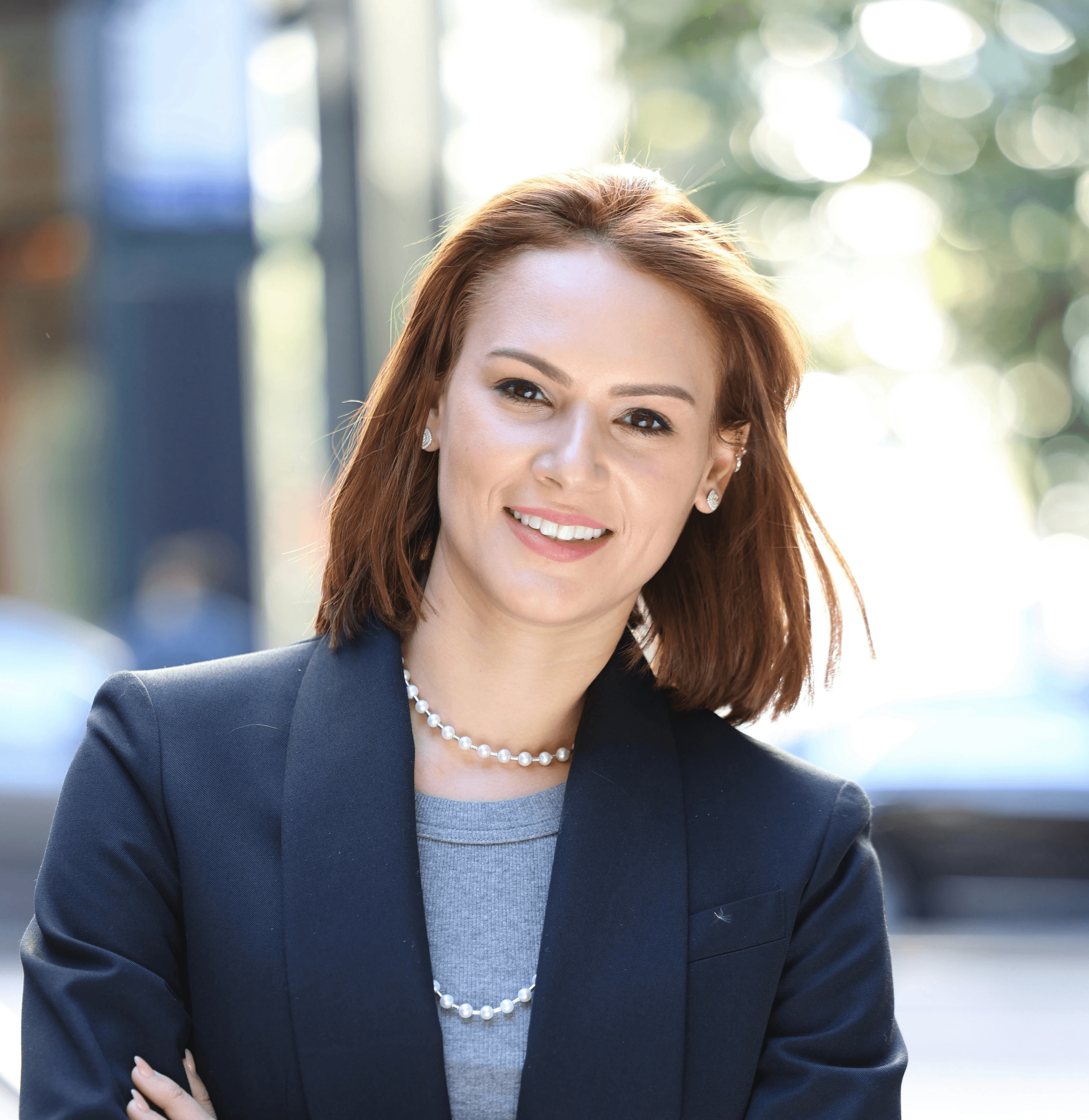 a woman with her arms crossed standing in front of a building