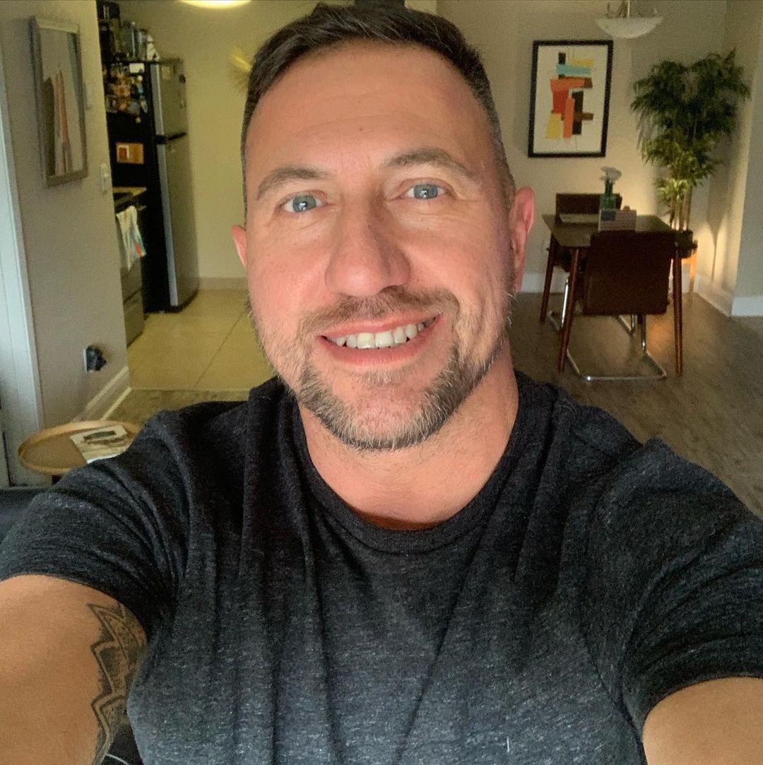 a man with a goatee smiles at the camera