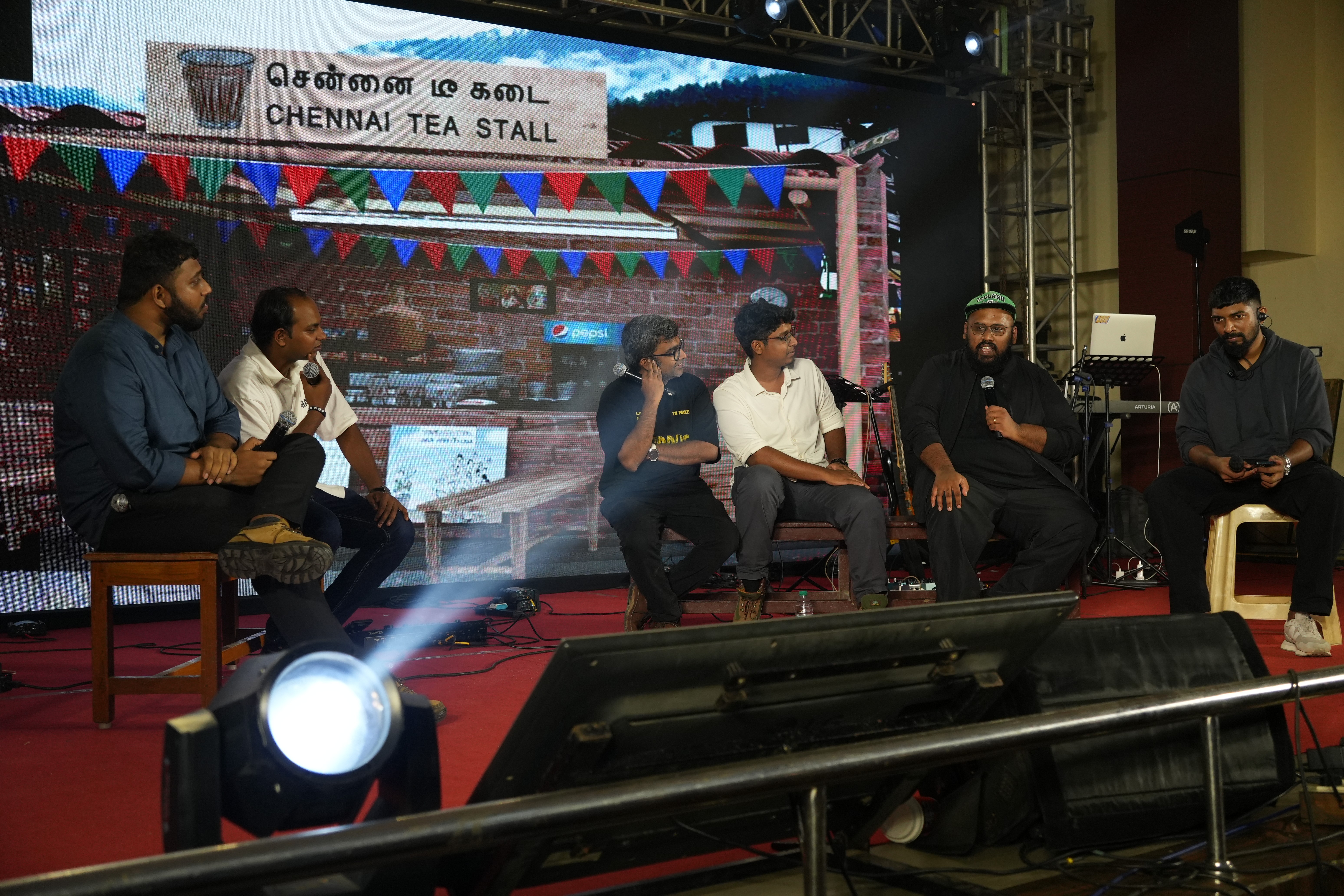 a group of people on a stage with a crowd watching