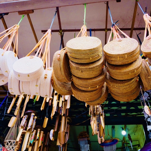 市場攤位上懸掛著編織的籃子和扇子。下面展示著各種木製品。