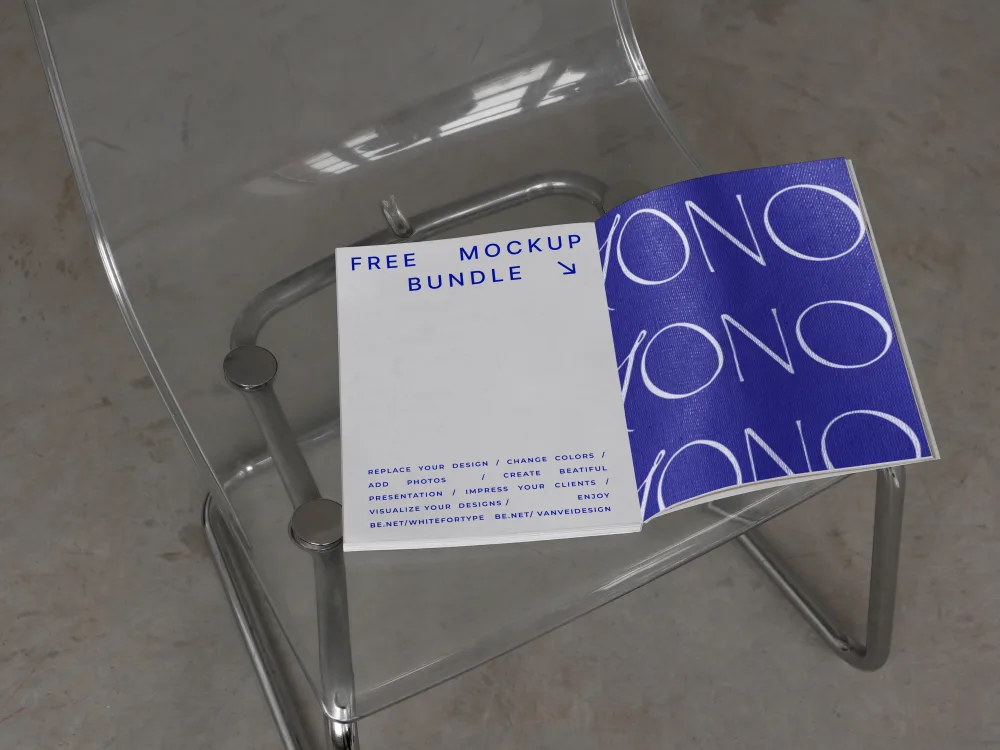 An open booklet mockup placed on a transparent acrylic chair. The left page is white with text, and the right page features a bold blue design. The scene is minimalistic with soft, natural lighting.