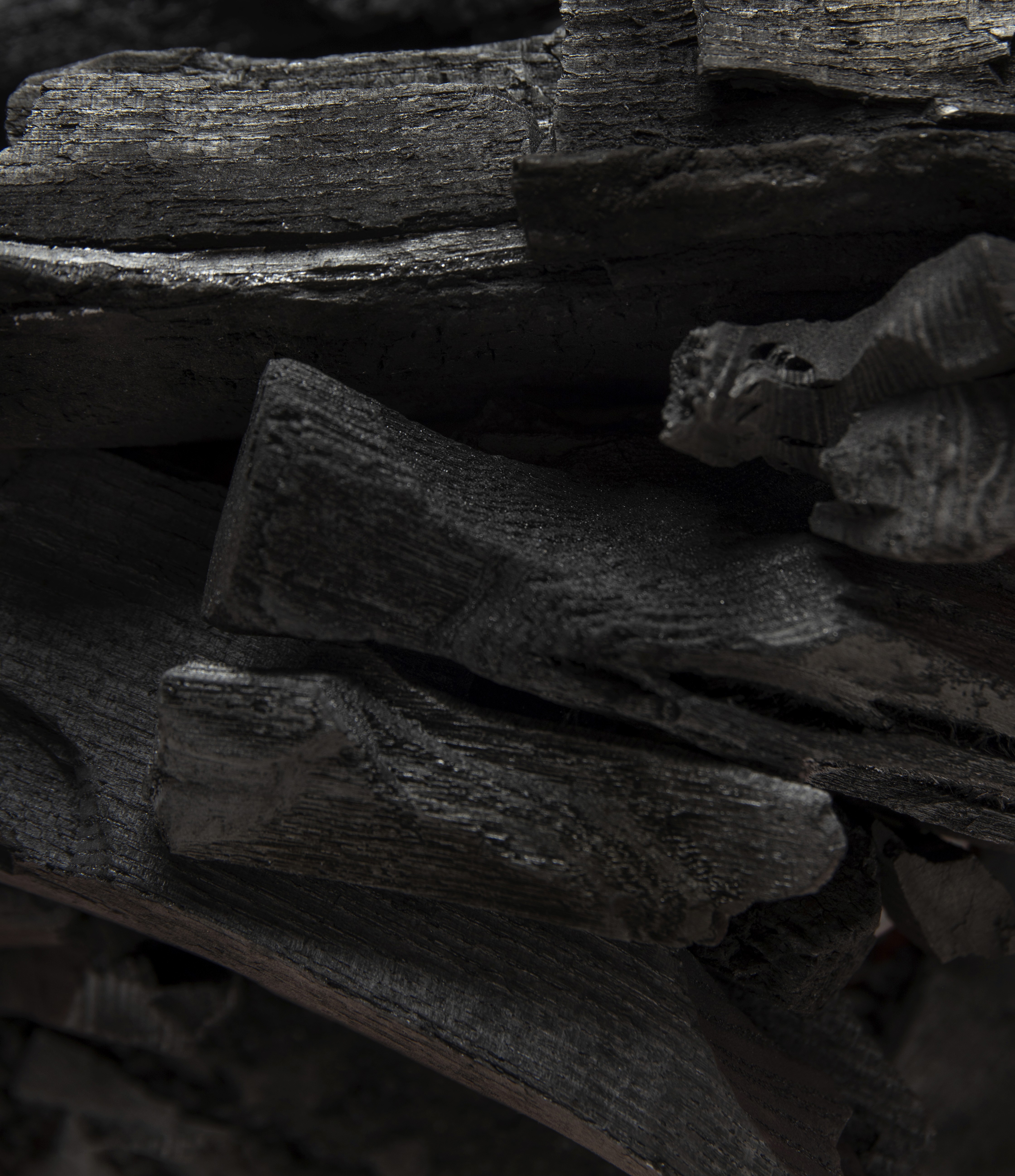 Dark charcoal sauna stones used as background texture for sauna heat and wellness theme.