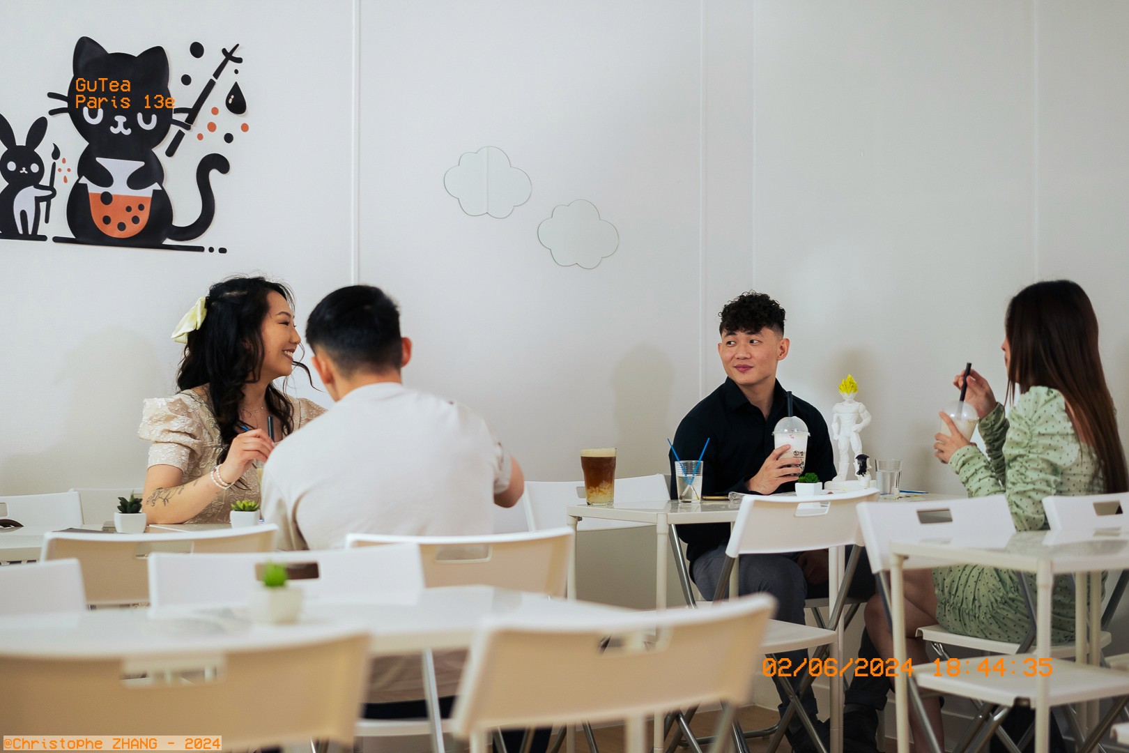 Groupe d'amis partageant un moment convivial chez GUTEA Paris 13e, avec des boissons et un décor mural