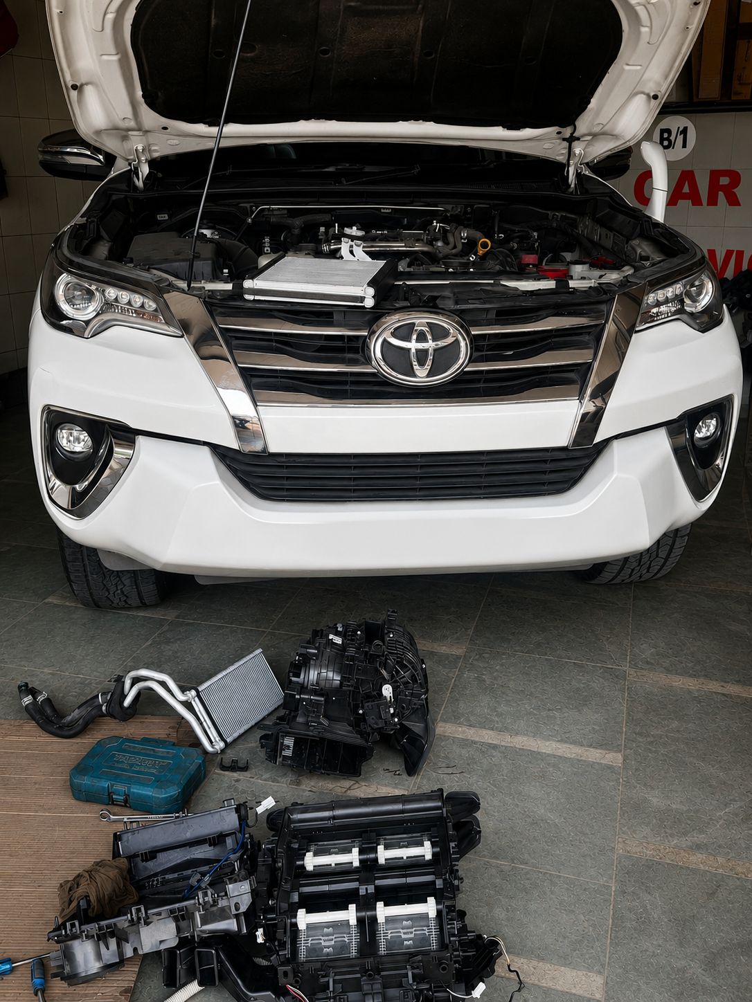 A mechanic is working on a yellow car.