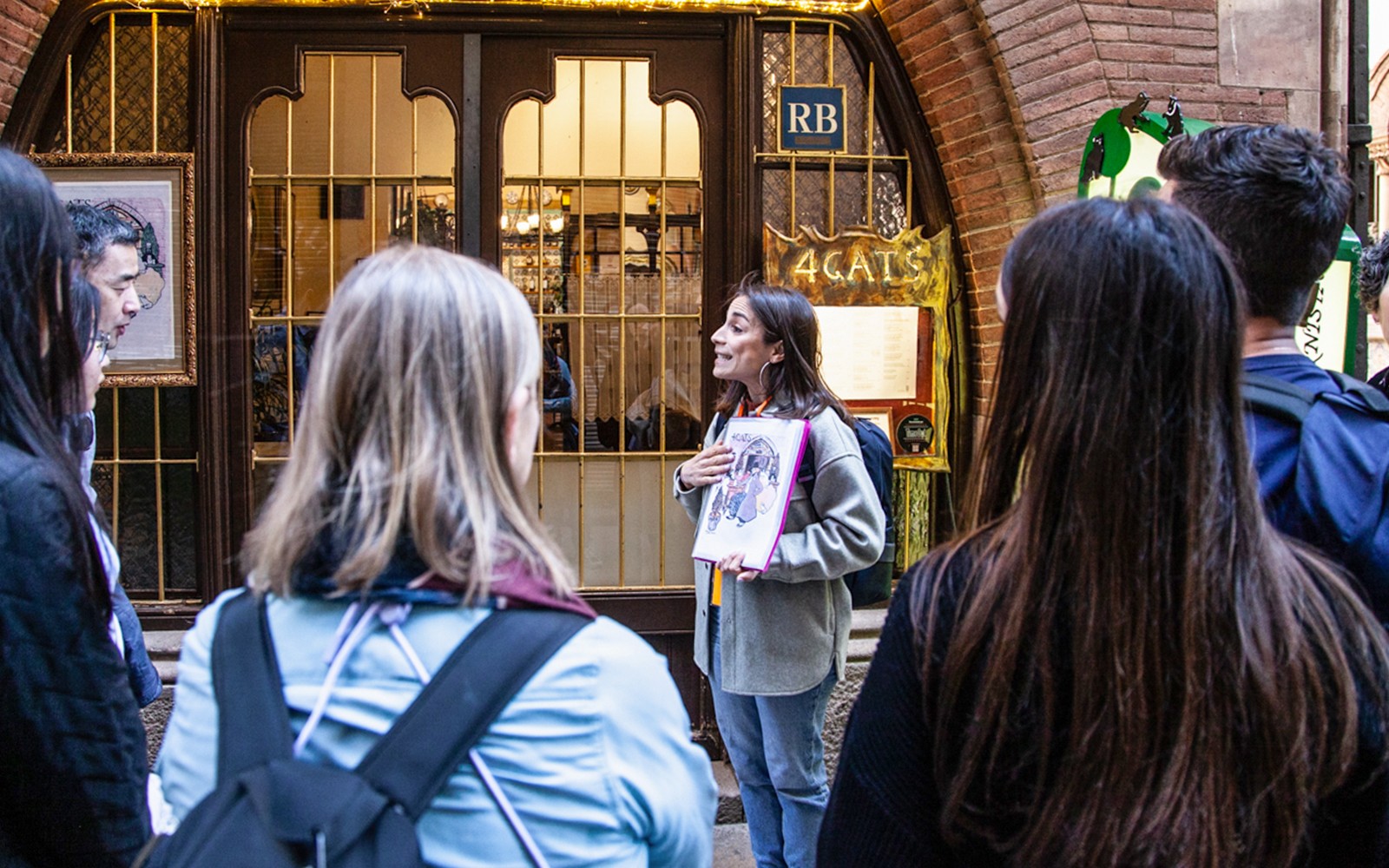 Guide explaining to visitors outside 4 Cats restaurant in Barcelona.