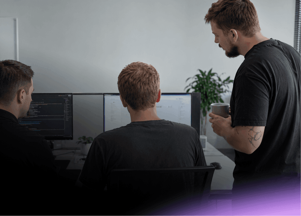 Nextio developers collaborating on custom software development and coding a web application on dual monitors.