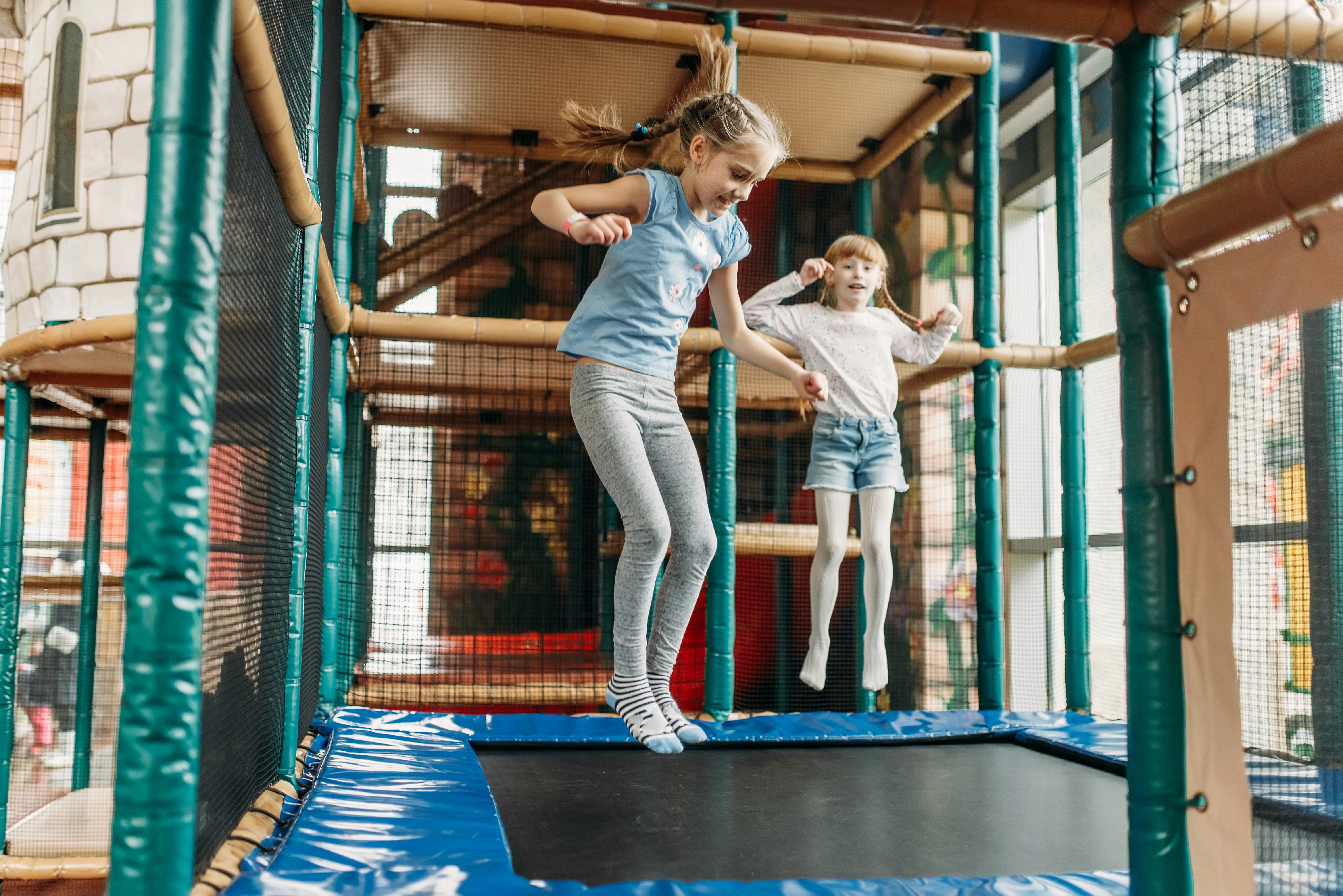 Kinder springen auf Trampolinen in einem Indoor Spiel- und Freizeitpark.