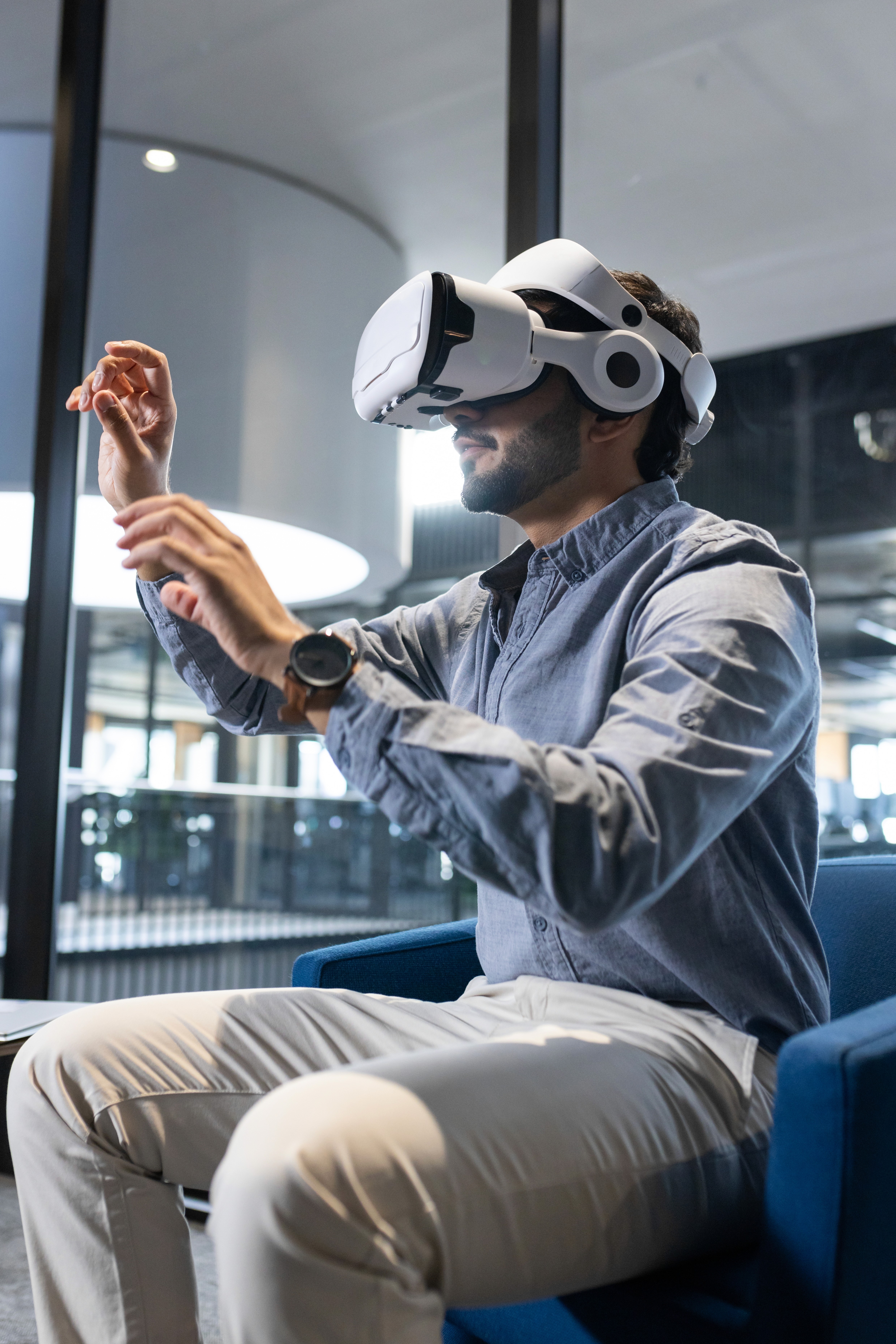 People seated around a table with laptops, 2 individuals engaged in work tasks.