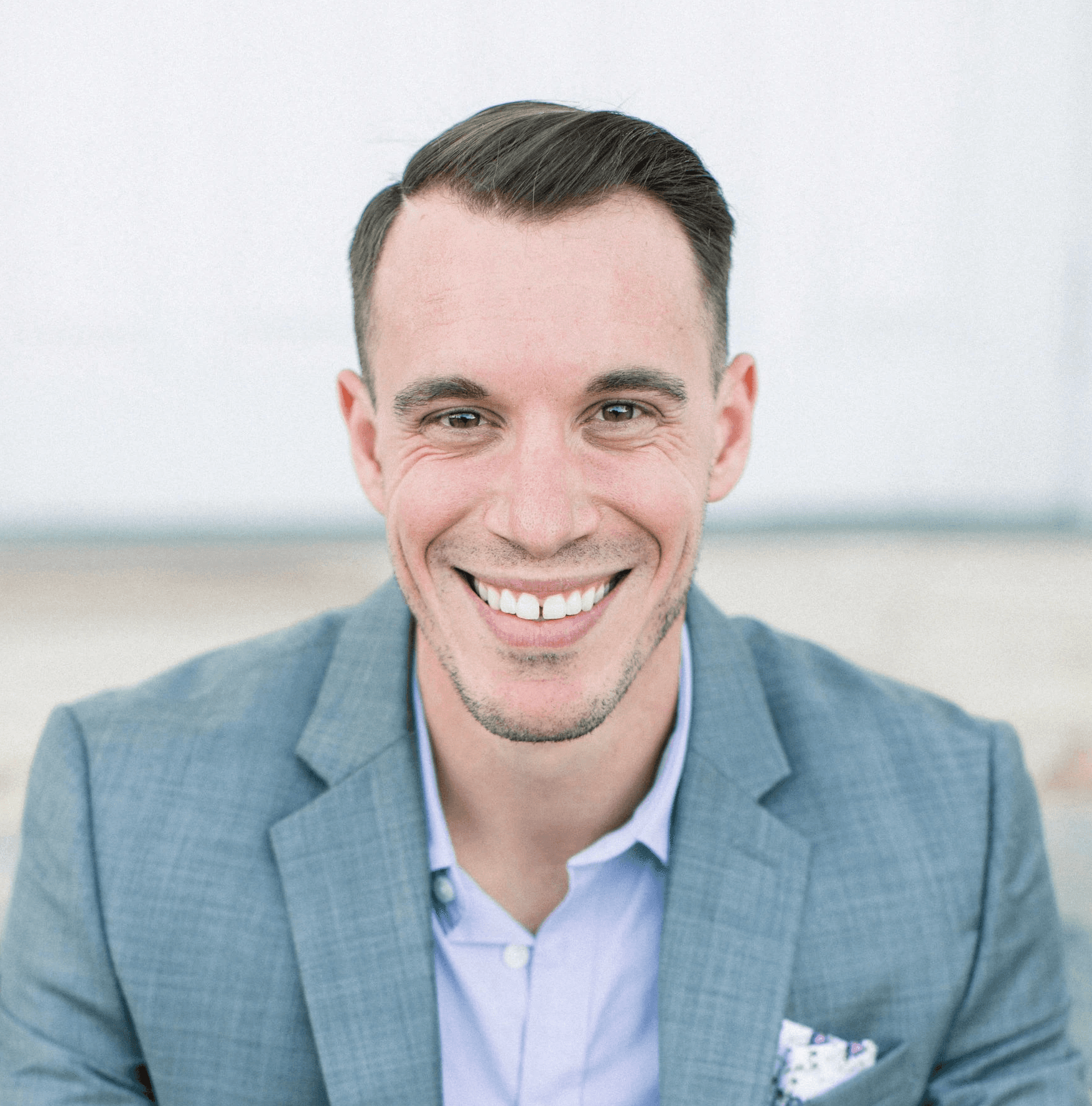 man in gray suit jacket sitting on gray concrete bench