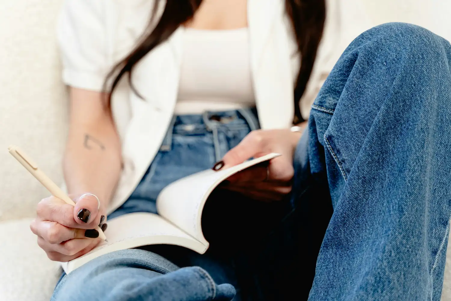 Hand writing in an open notebook with a red pen