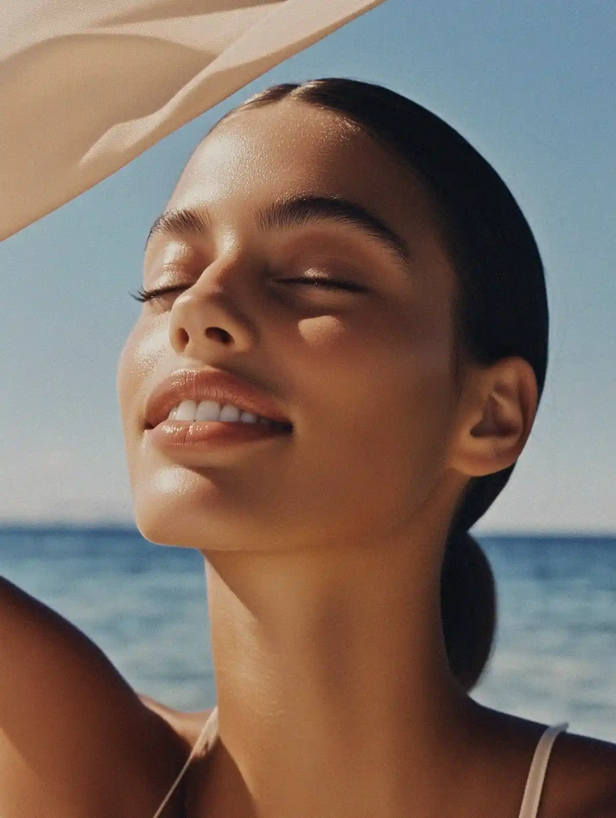 Elegant close-up of a shoulder, showcasing flawless skin and manicured nails with a soft, radiant texture.