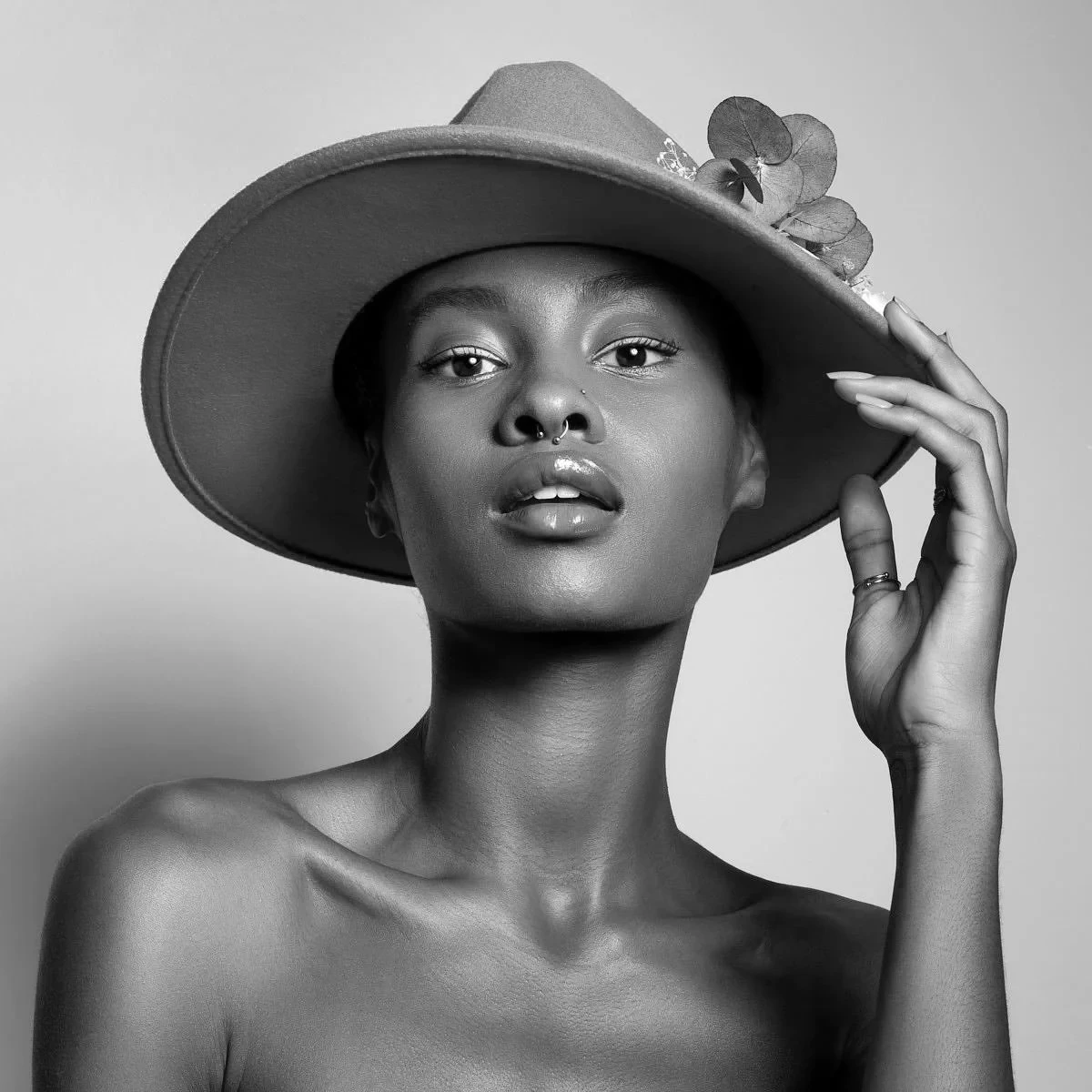 Shooting de mode éditorial en intérieur : mannequin assise dans une chaise en bois ornée, regard intense — Production visuelle haut de gamme à La Réunion