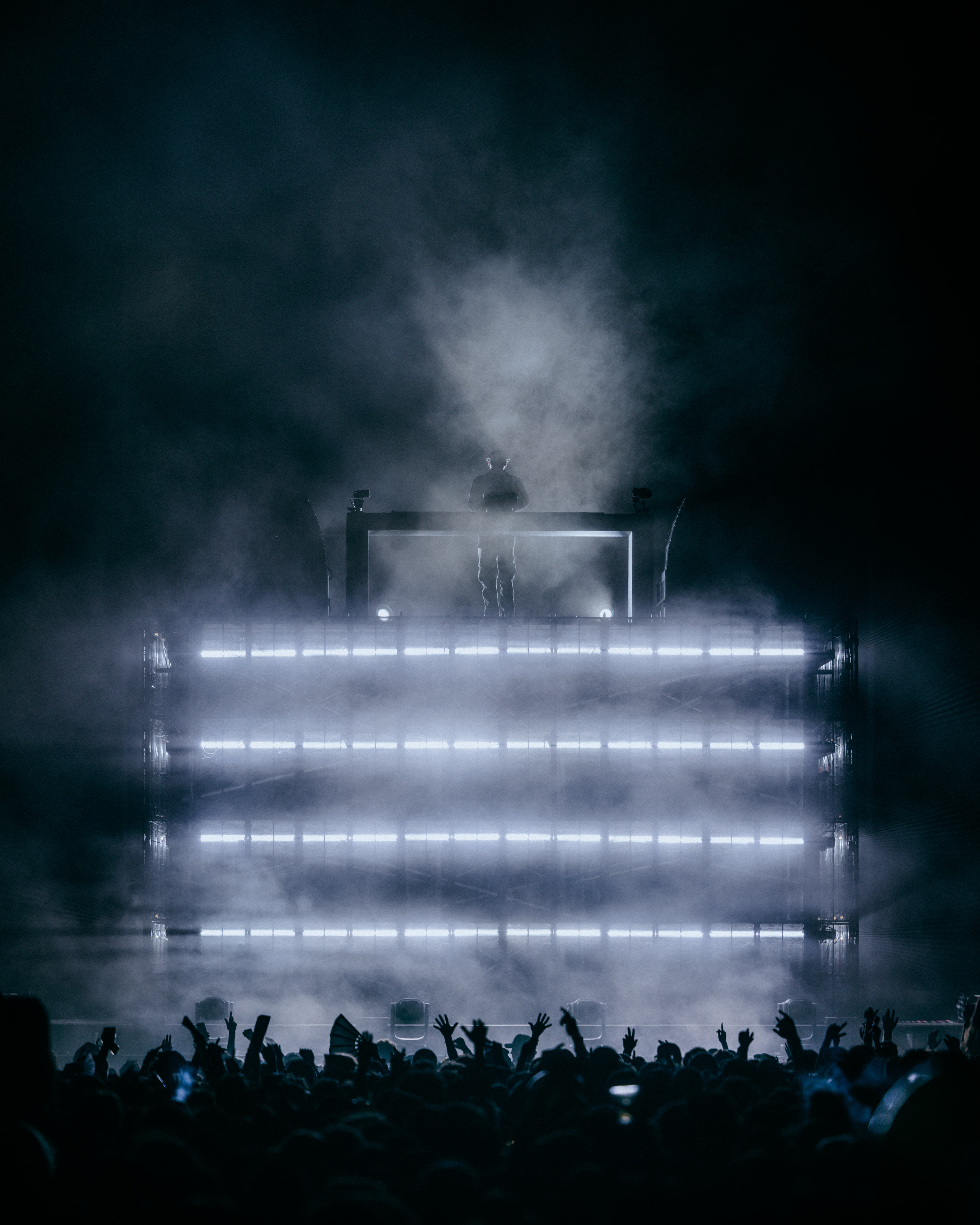 Dom Dolla framed in atmospheric lighting and haze above a packed LA State Historic Park crowd, photographed by Brandon Densley of A World Away