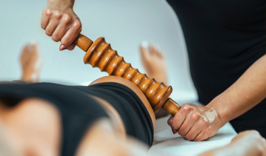 séance de madérothérapie avec rouleau en bois pour stimuler la circulation et raffermir la peau à Laval