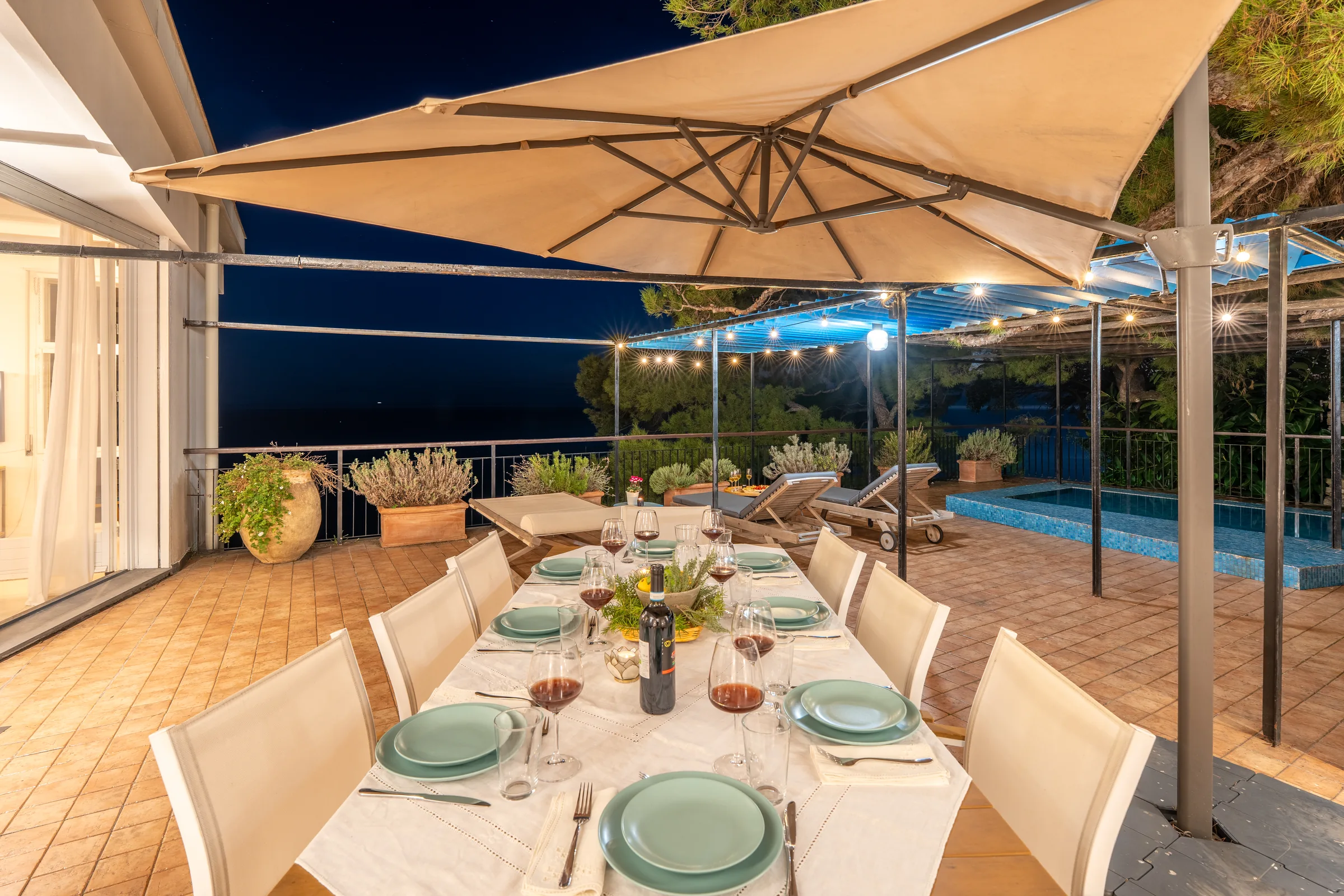 Outdoor dining terrace at night — Sori, Italian Riviera. Photography by Yunes Calore.