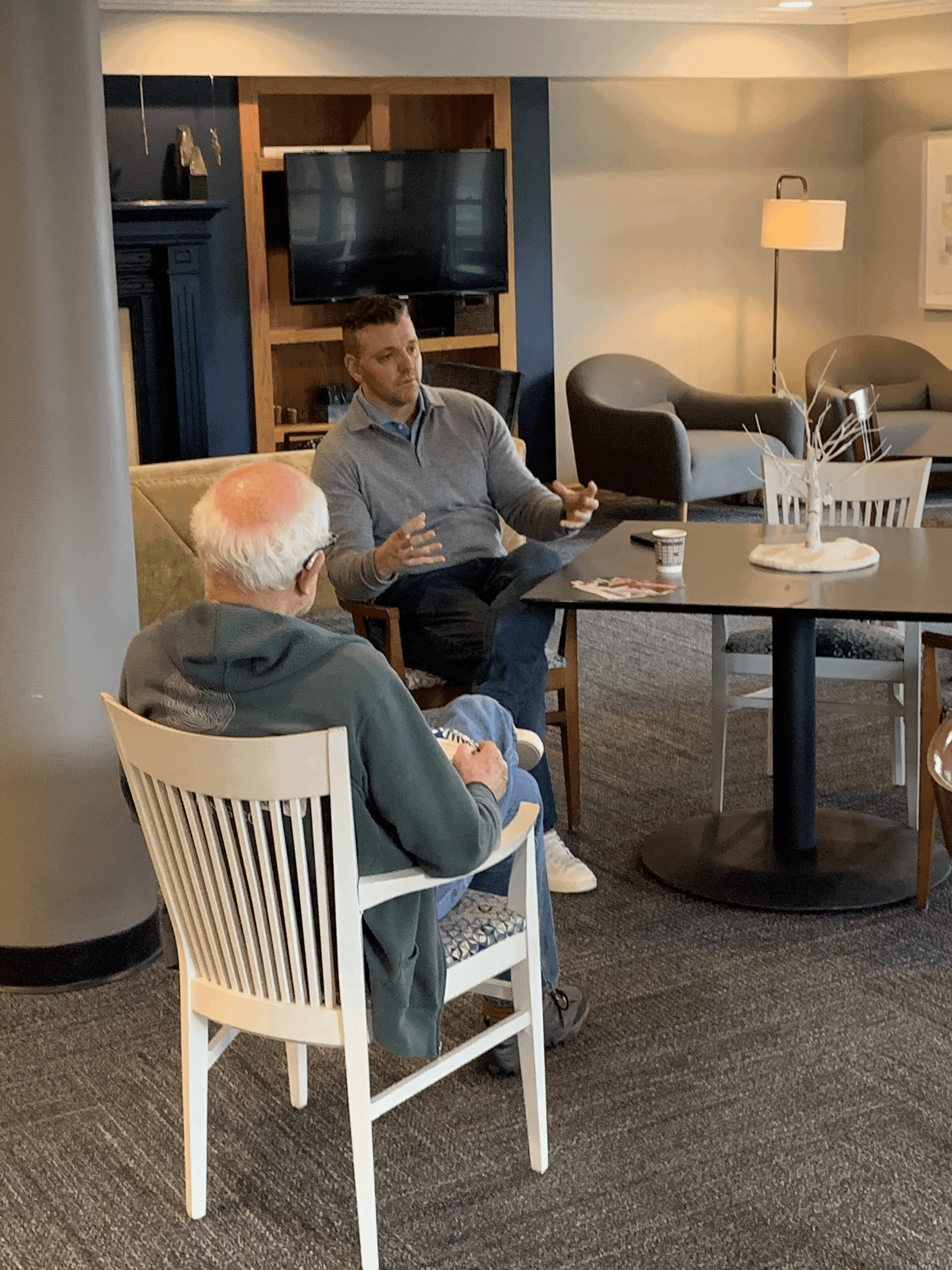 woman sitting around table holding tablet