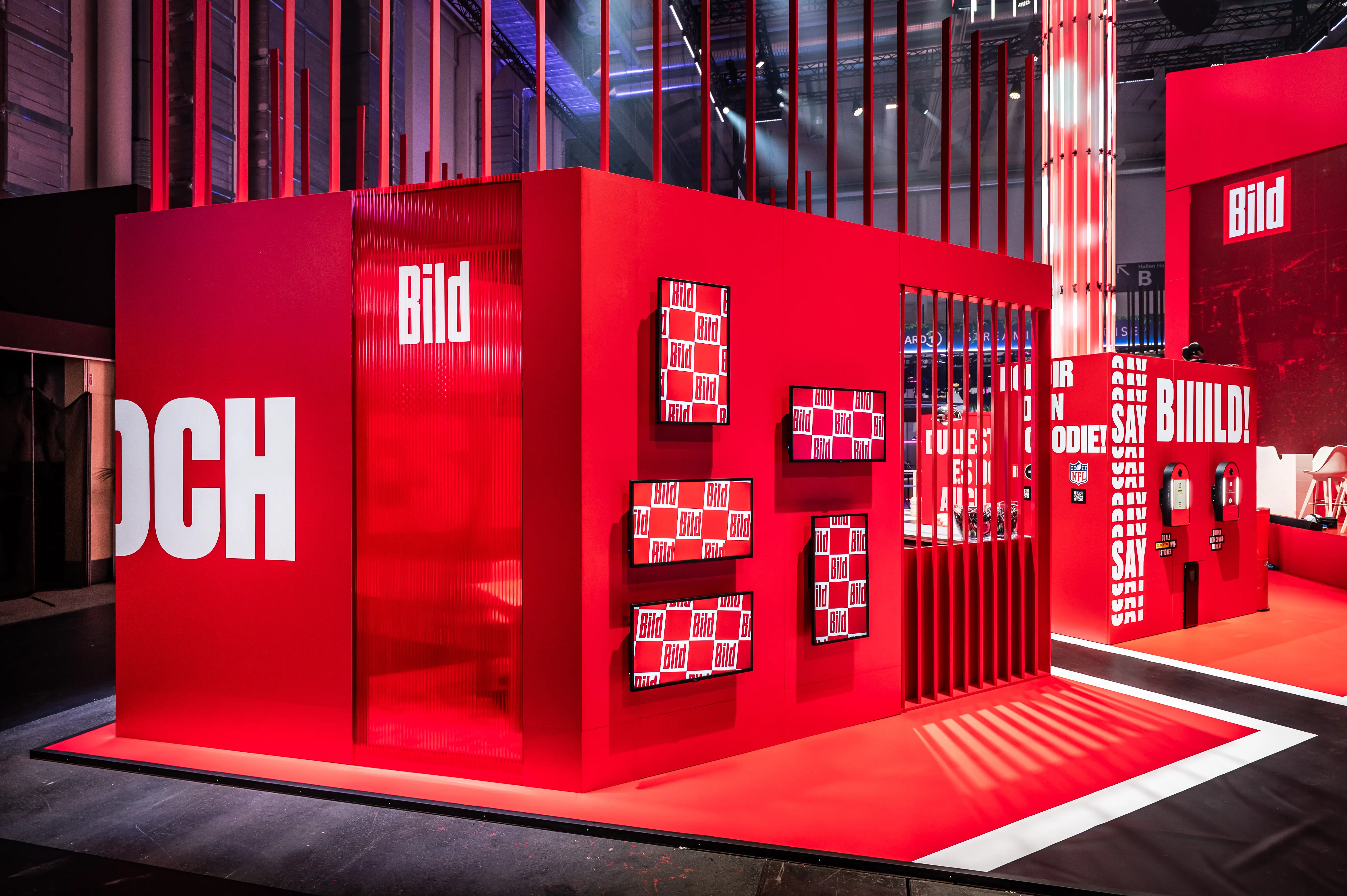Red Bild cube with logo screens in checkerboard design and oversized white typography on the facade.