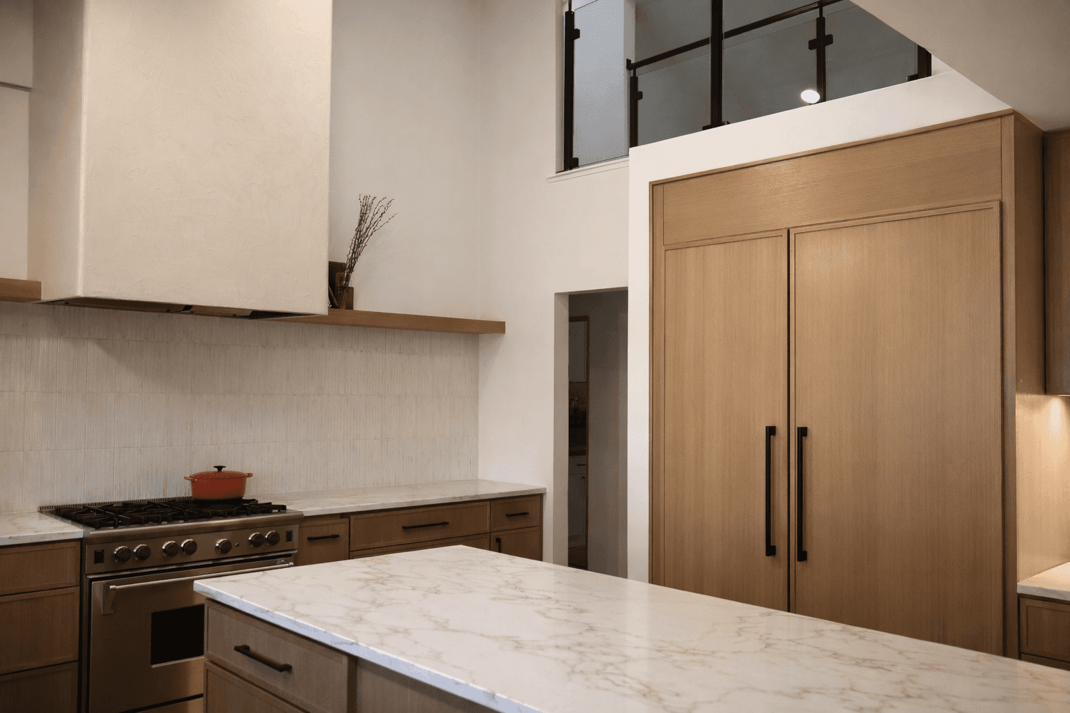 Custom white oak cabinetry with plaster range hood and professional gas range by QW Kitchen & Bath Austin