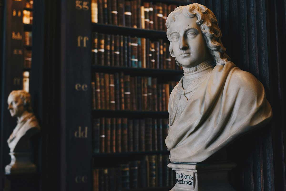 Marble bust in a historic law library surrounded by legal books, symbolizing tradition and expertise in the legal profession.