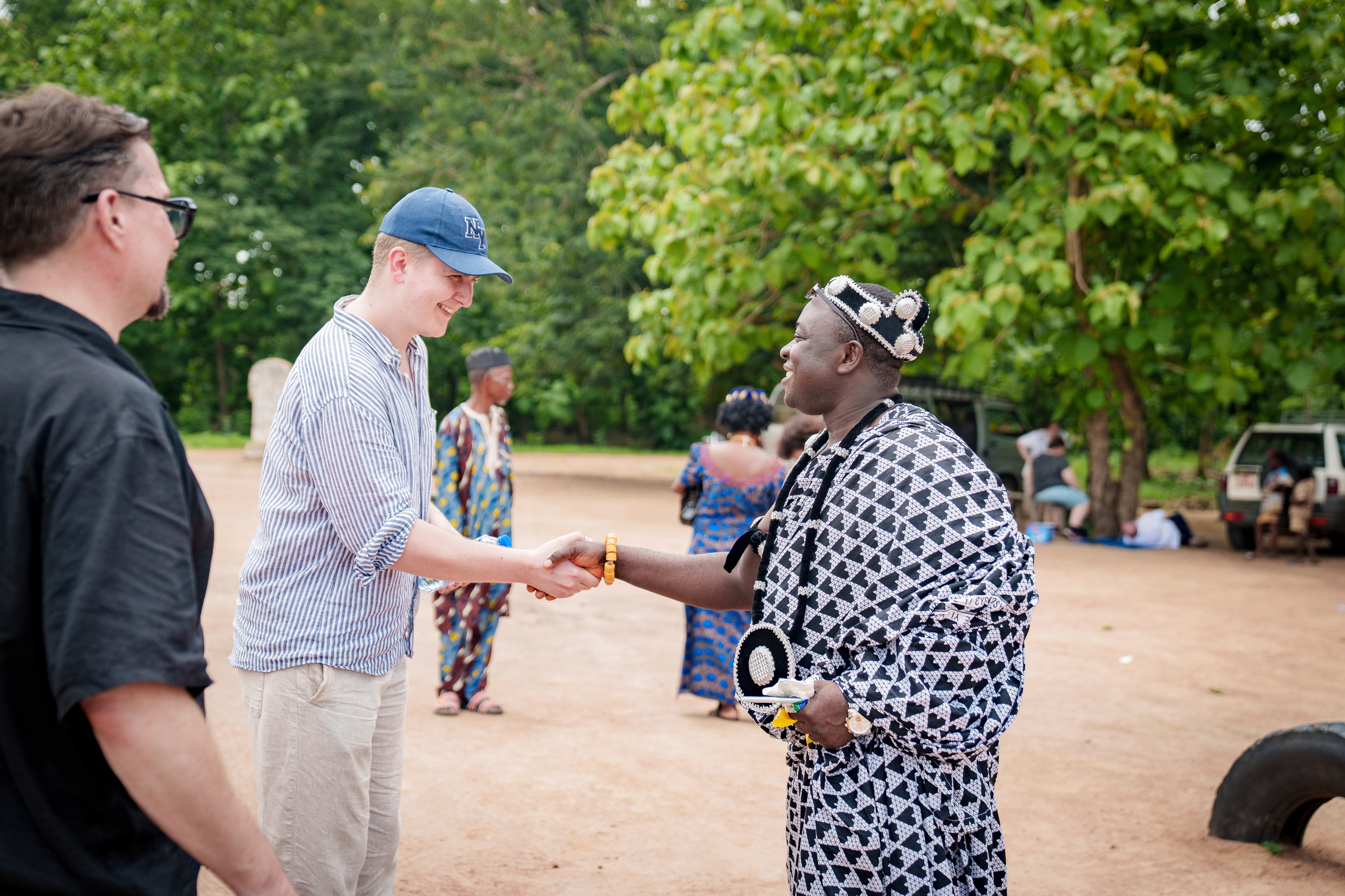 Zwei Personen reichen sich bei einem Treffen im PROJECT TOGO die Hand.
