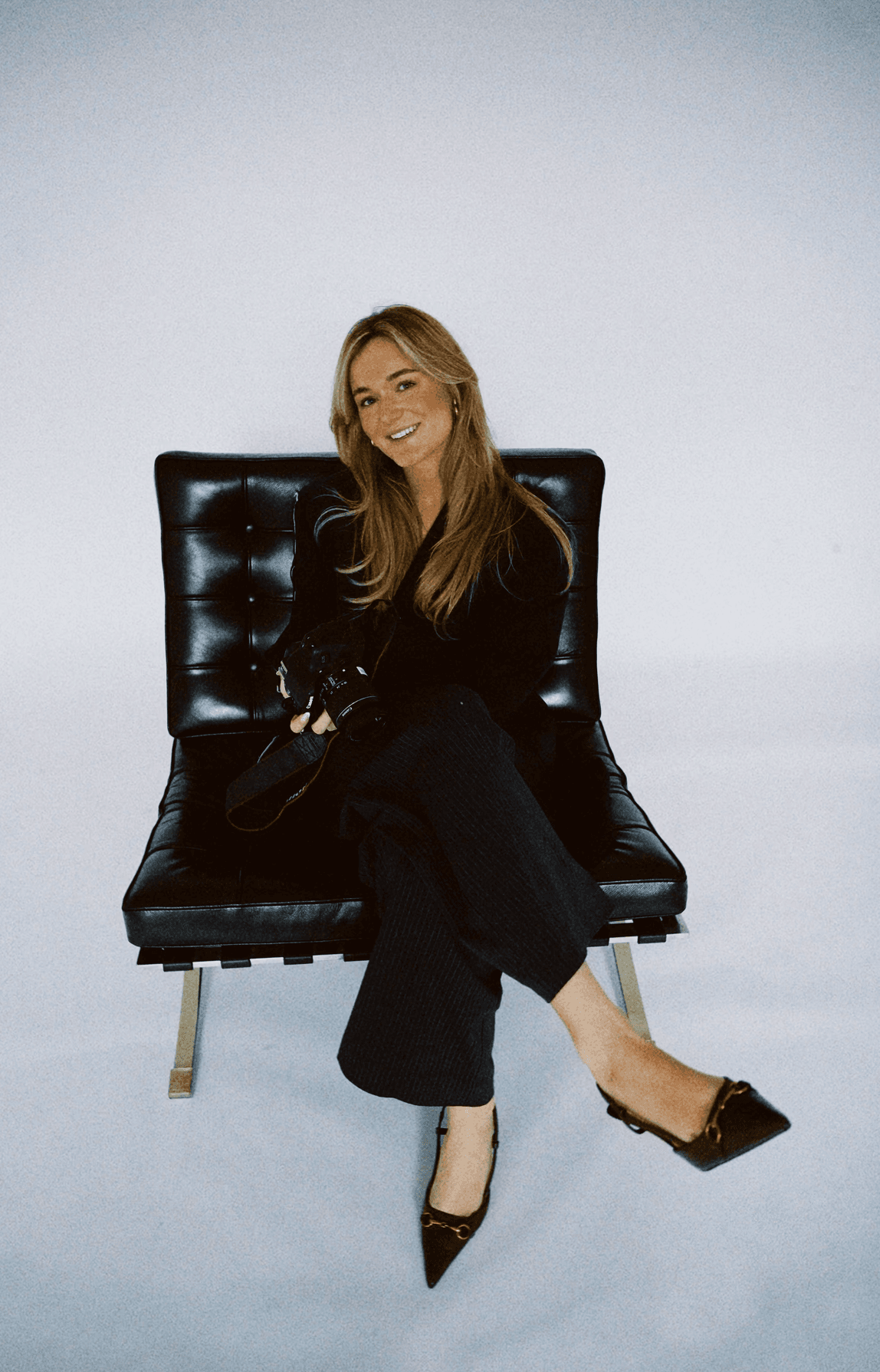 Portrait of a person in a pink sweater against a light background