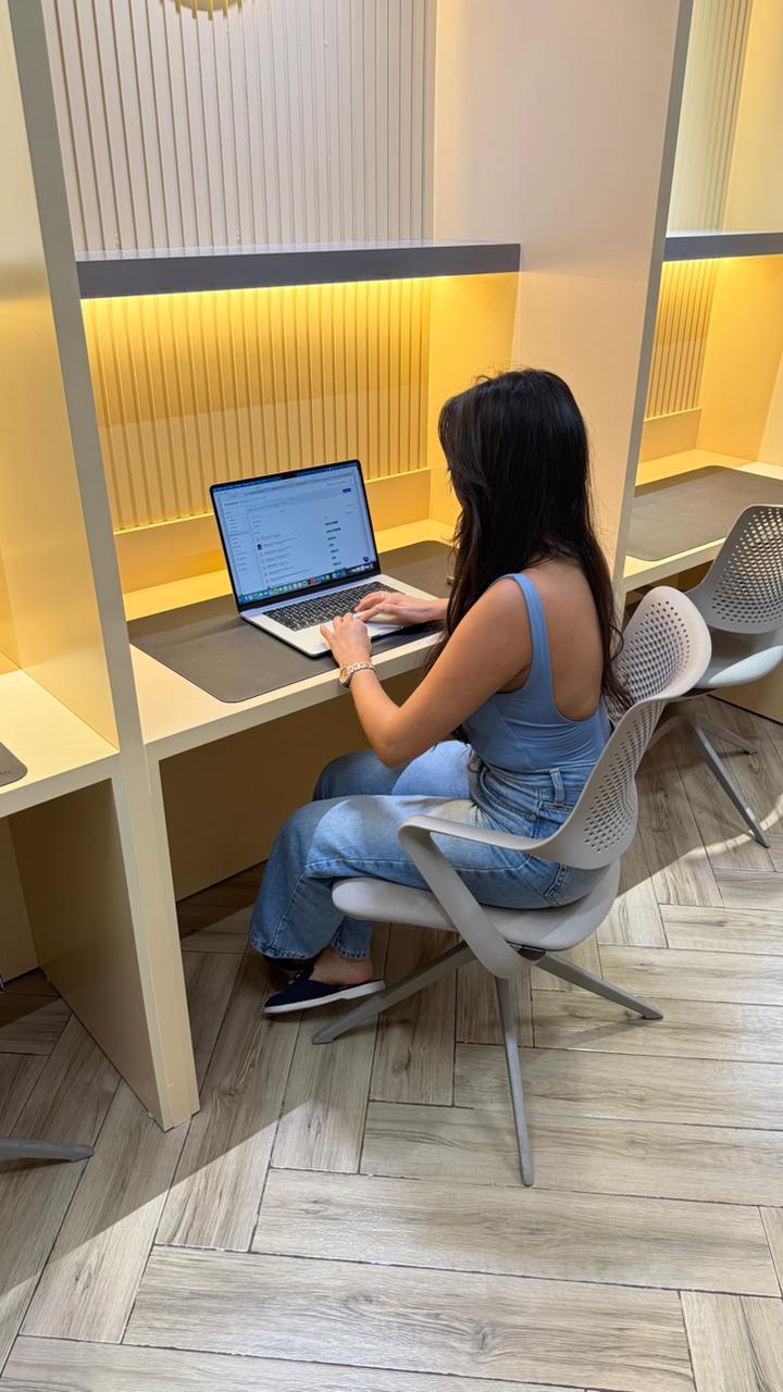 Colorful creative workspace with a desktop computer surrounded by vibrant retro-style posters and artwork on the wall