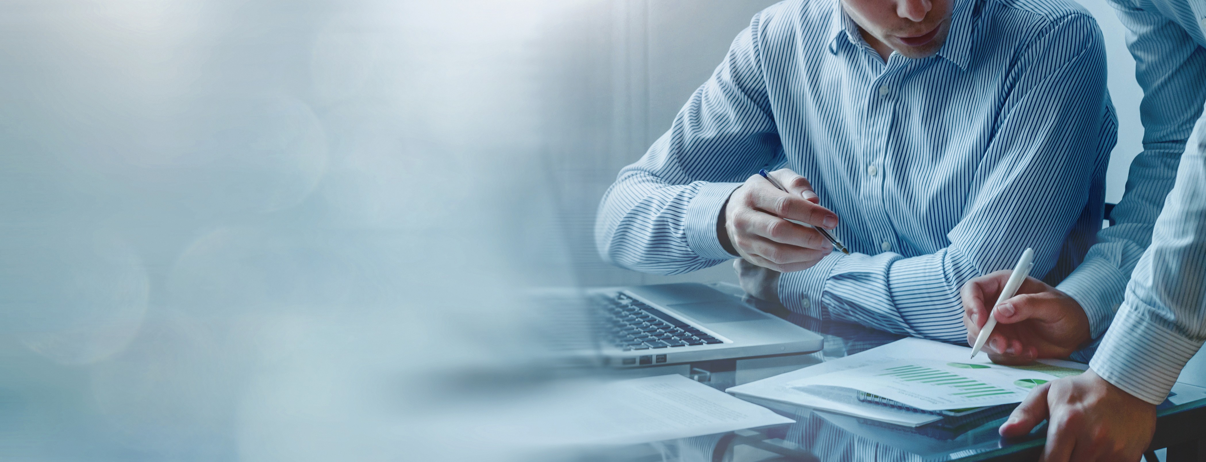 Zwei Fachleute überprüfen Notizen und Berechnungen an einem Schreibtisch, welche die Grundlagen des Ressourcenmanagements darstellen, mit bewussten Entscheidungen über Personal, Zeit und Budget in Managementsystemen.