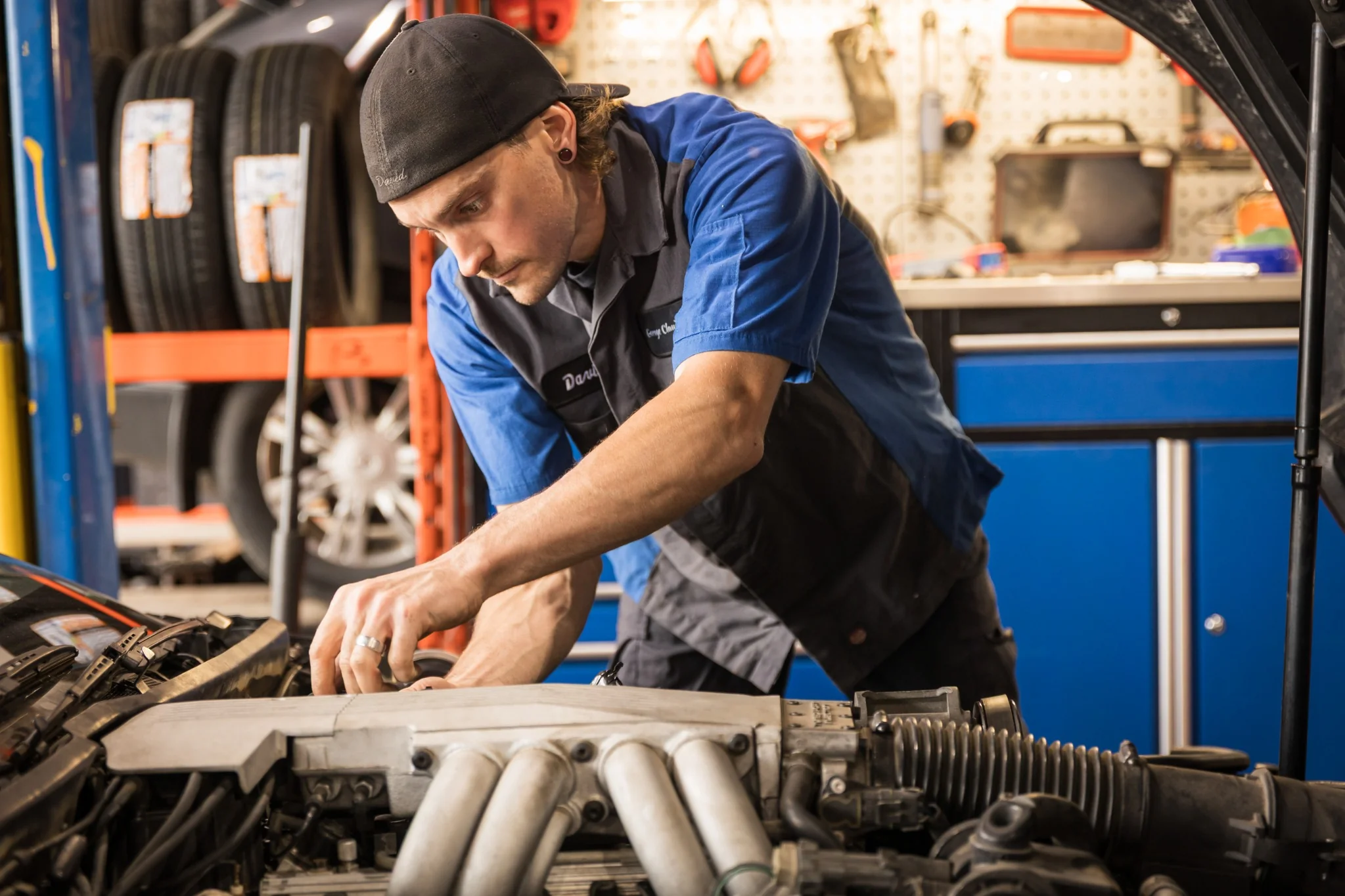 Mécaniciens du garage Claude Coutu en train de réparer un moteur, démontrant leur expertise technique à Saint-Constant