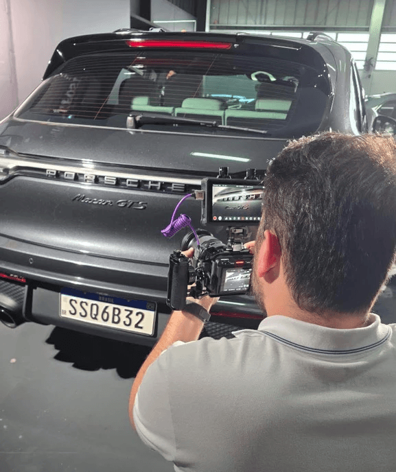 Videomaker da Casa Oito Estúdio filmando a traseira da Porsche Macan GTS ainda cinza chumbo, antes do envelopamento na Revo Solutions em Brusque, SC