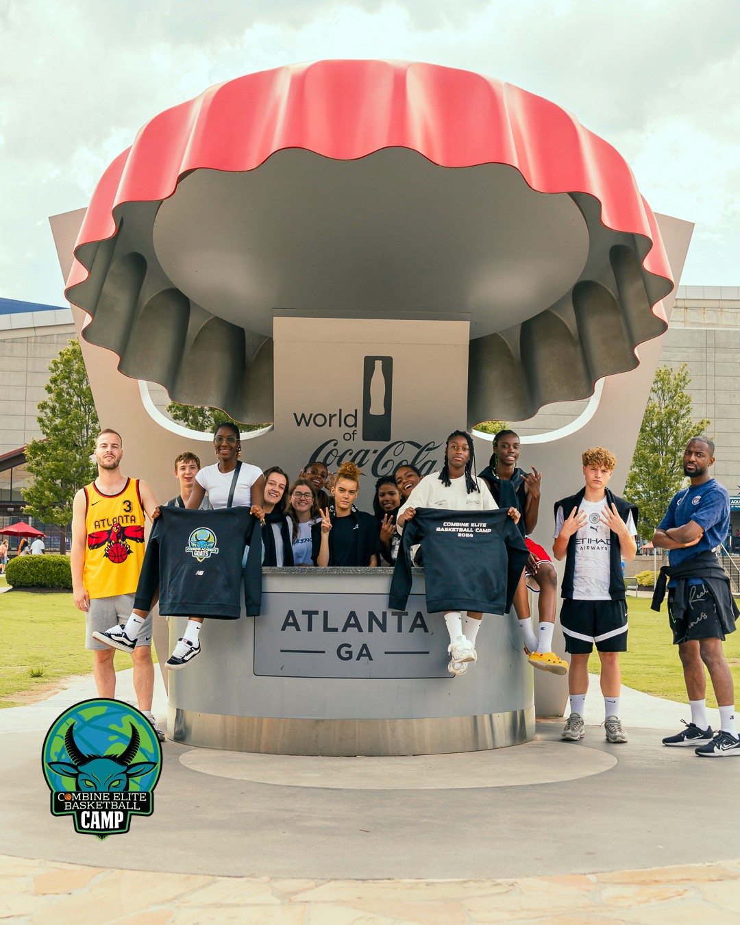 Groupe de jeunes posant devant la sculpture "World of Coca-Cola" à Atlanta.